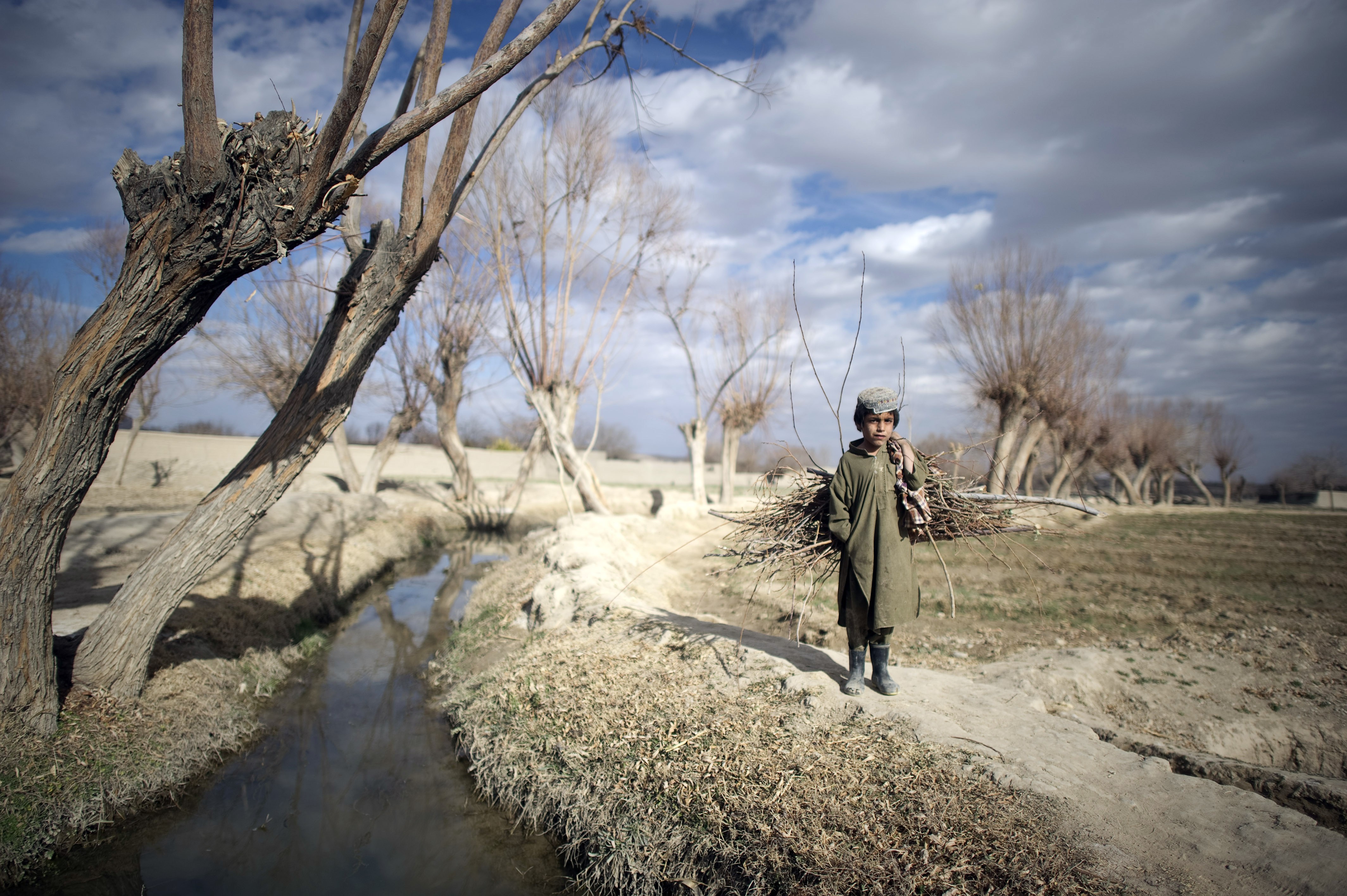 An Afghan boy watches US Marines on foot patrol outside the Musa Qala district base in January, 2011. Picture: AFP