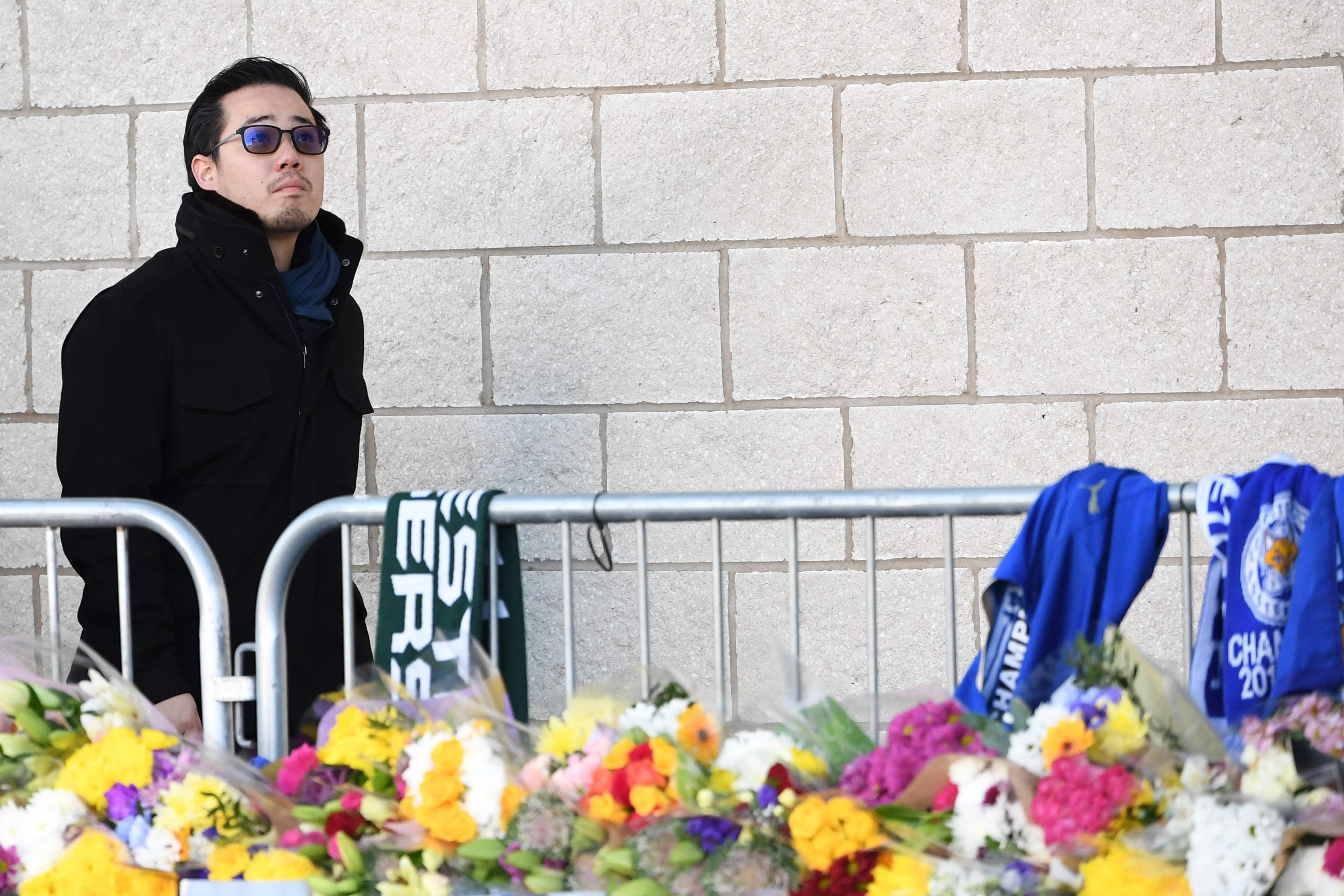 Aiyawatt Srivaddhanaprabha, the son of Leicester City chairman Vichai Srivaddhanaprabha, who died in a helicopter crash at the club’s stadium, looks at the floral tributes left to the victims of the crash. Photo: AFP