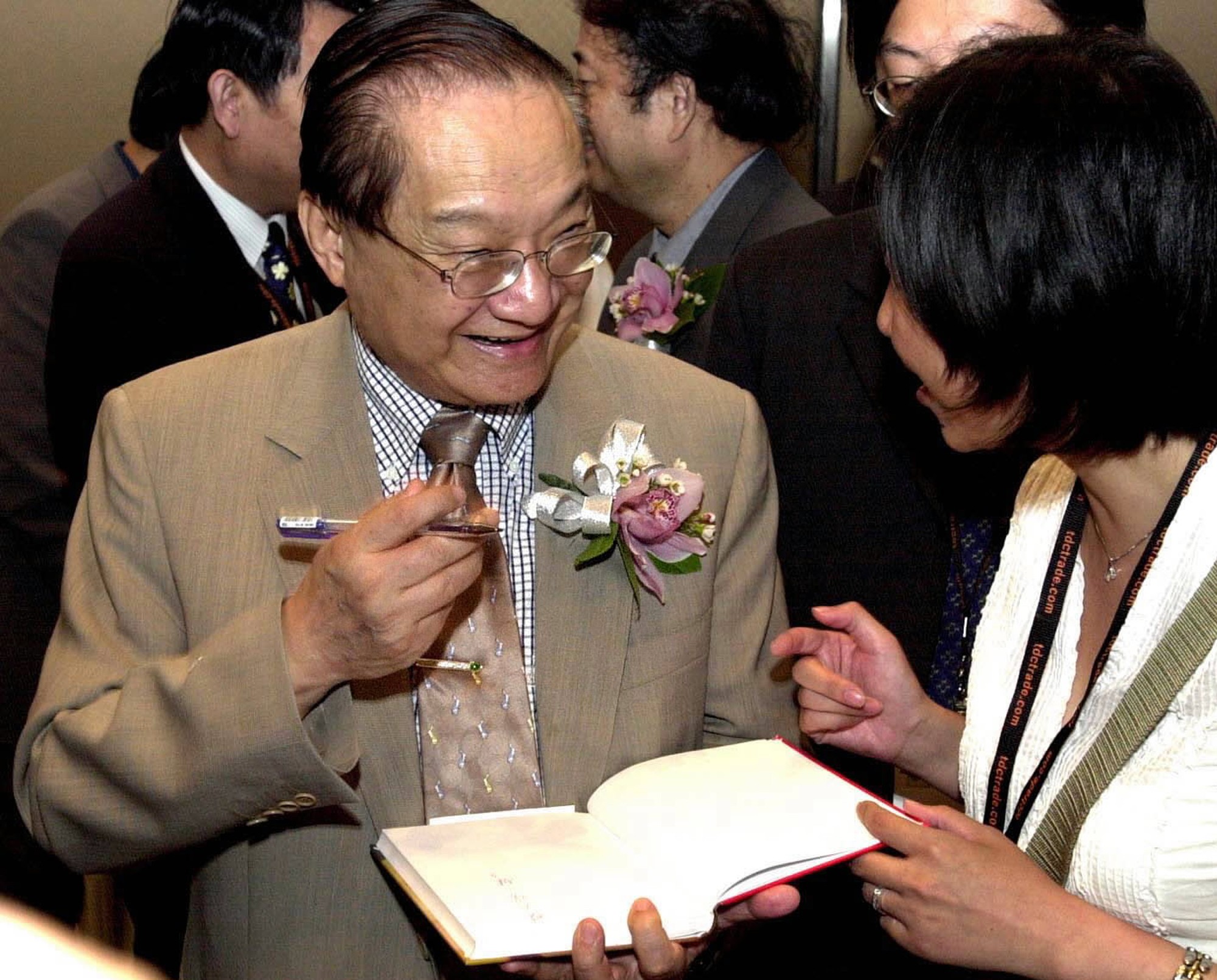 Louis Cha signs a book for a reader at the Hong Kong Book Fair. Photo: AP