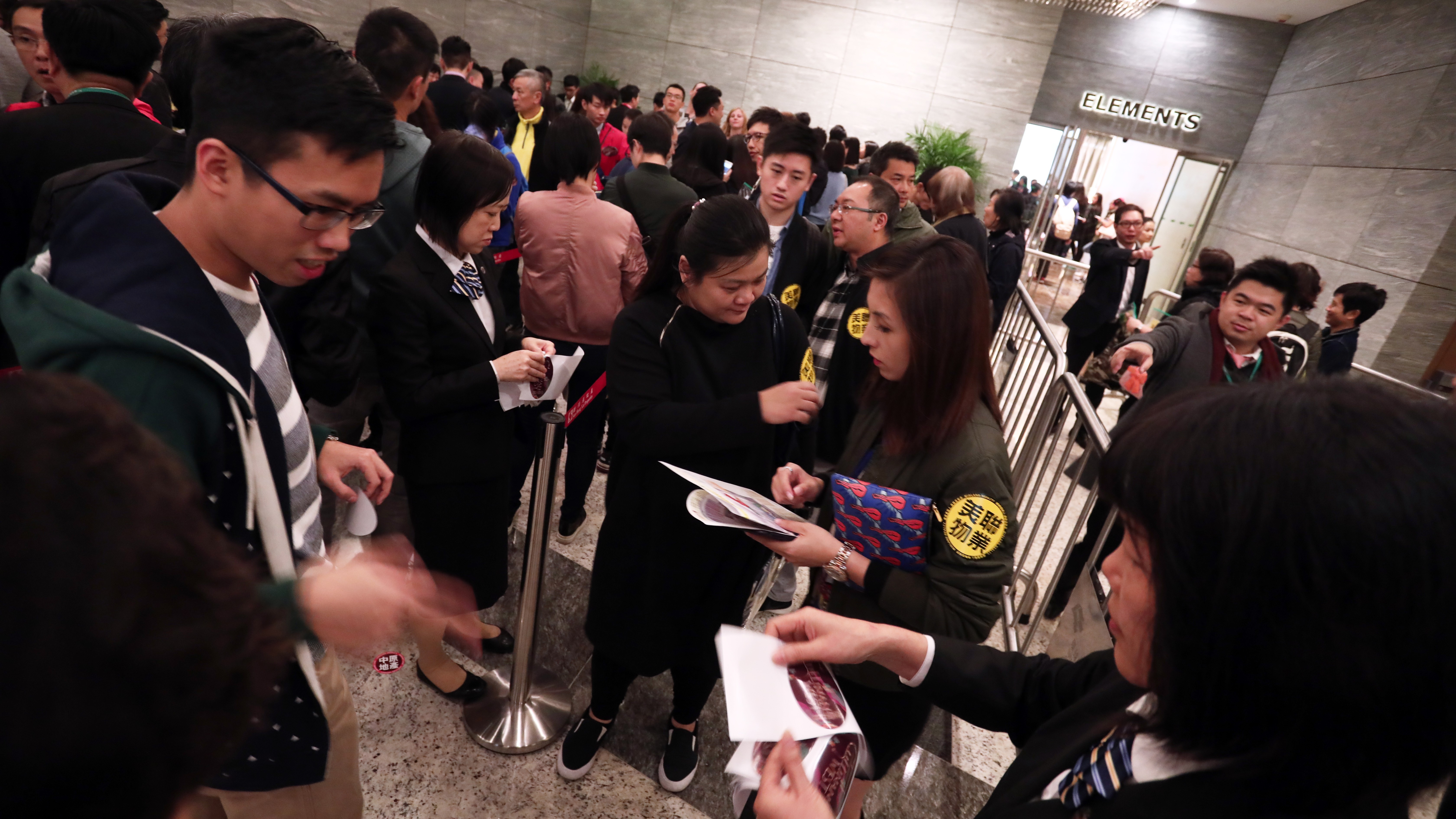 Property agents solicit prospective homebuyers at the sale office of a new development in Hong Kong. Photo: Jonathan Wong