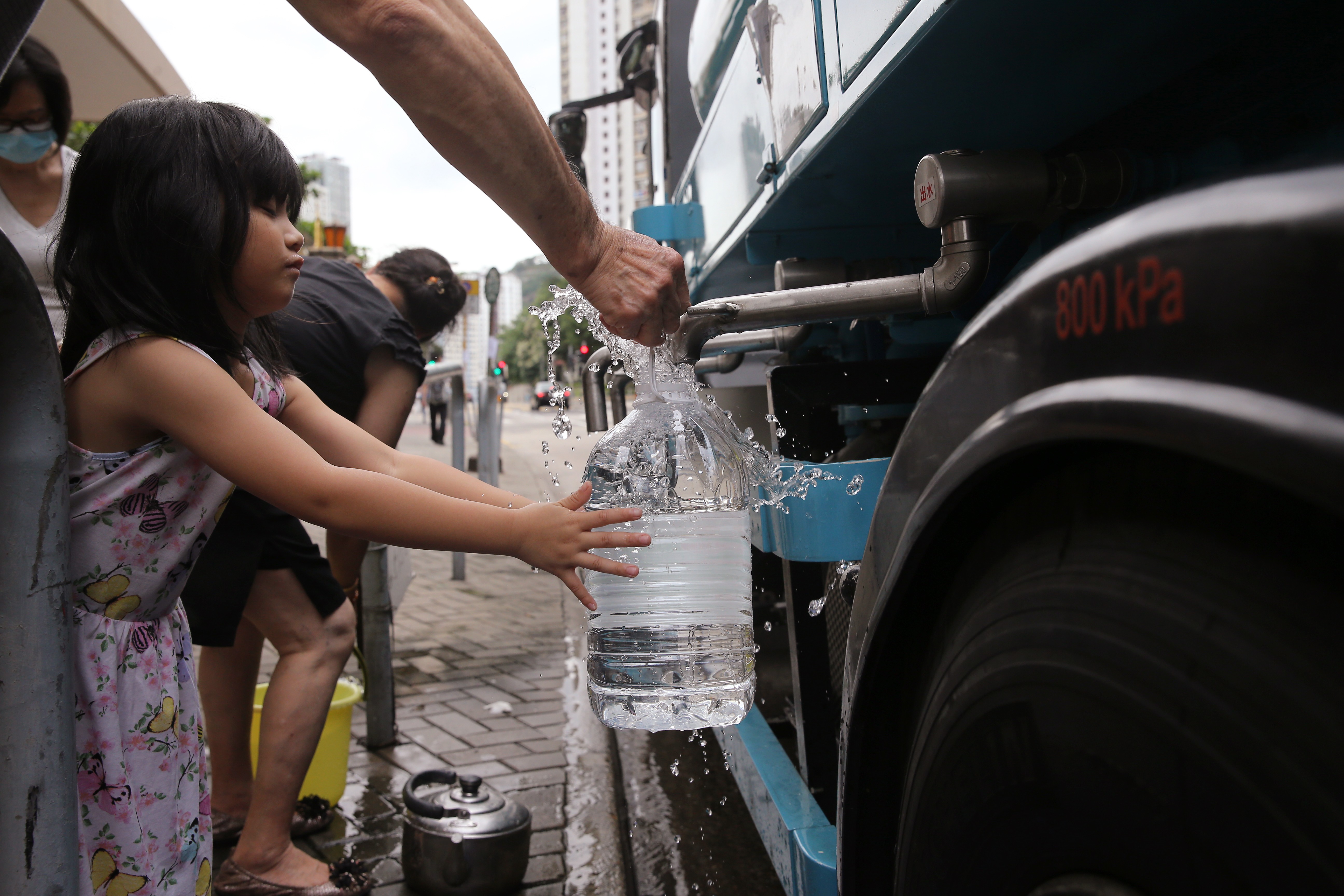 Residents fill up containers of drinking water from a temporary standpipe, after a partial power failure at Hiu Kwong Street in Sau Mau Ping in June 2016. Photo: Sam Tsang
