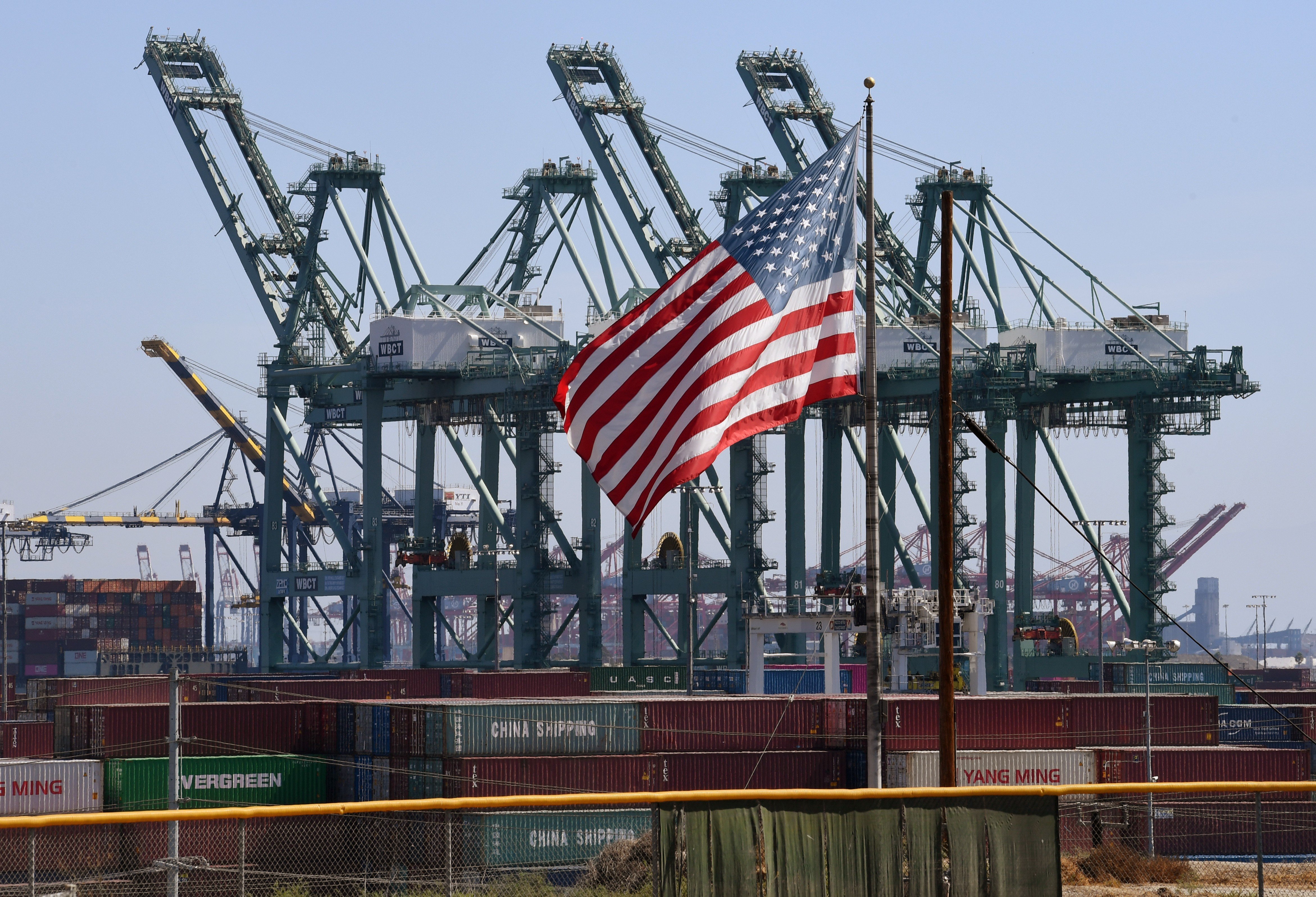 The US flag flies over Chinese shipping containers at the Port of Long Beach in Los Angeles County on September 29, 2018. American companies including Boeing, Dow, General Motors, GE, Ford and Tesla together made up the third-largest congregation of exhibitors at the China International Import Expo in Shanghai from November 5 to 8, 018. Photo: AFP