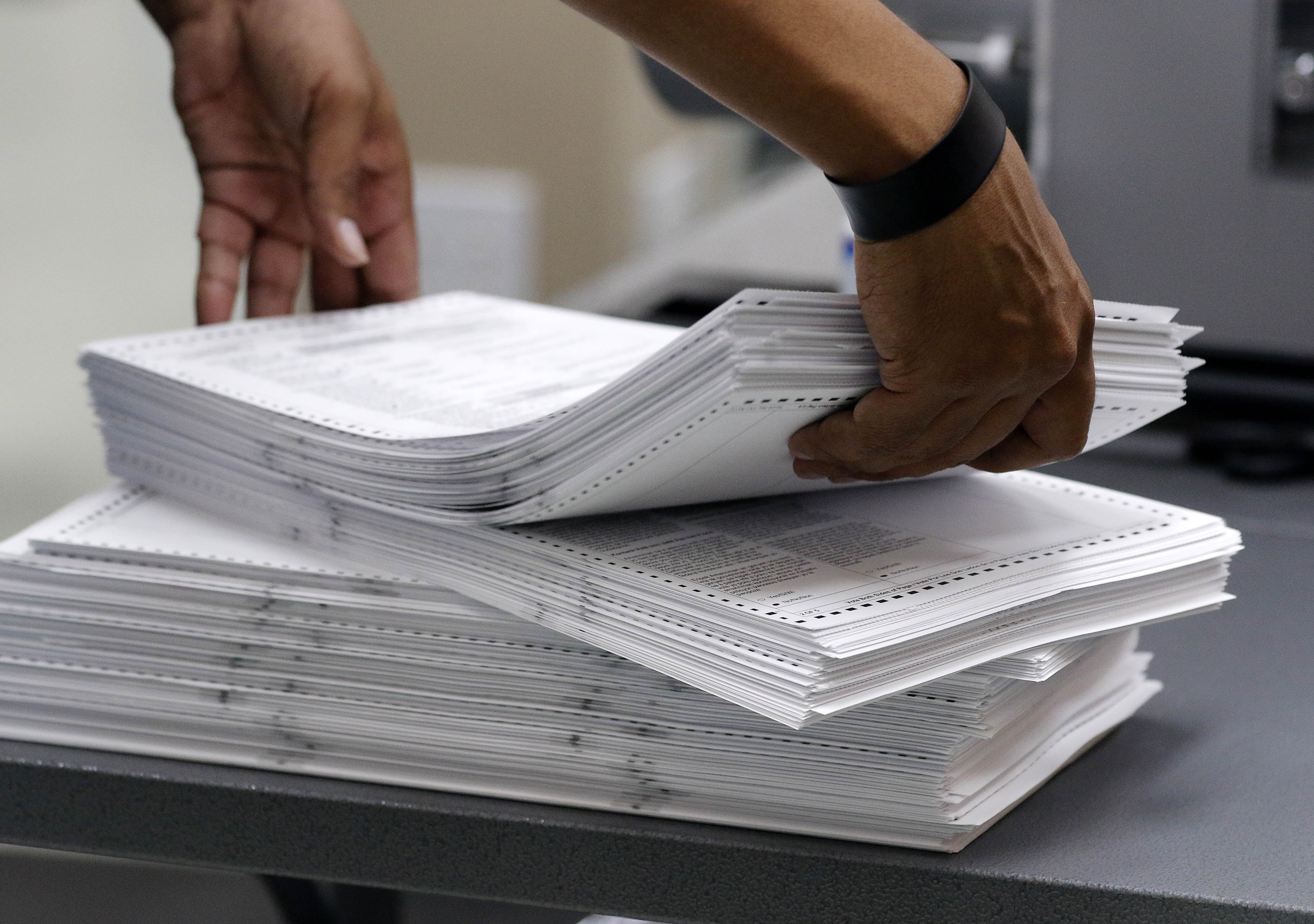 Elections staff load ballots into machine as recounting is underway at the Broward County Supervisor of Elections Office. Photo: AFP