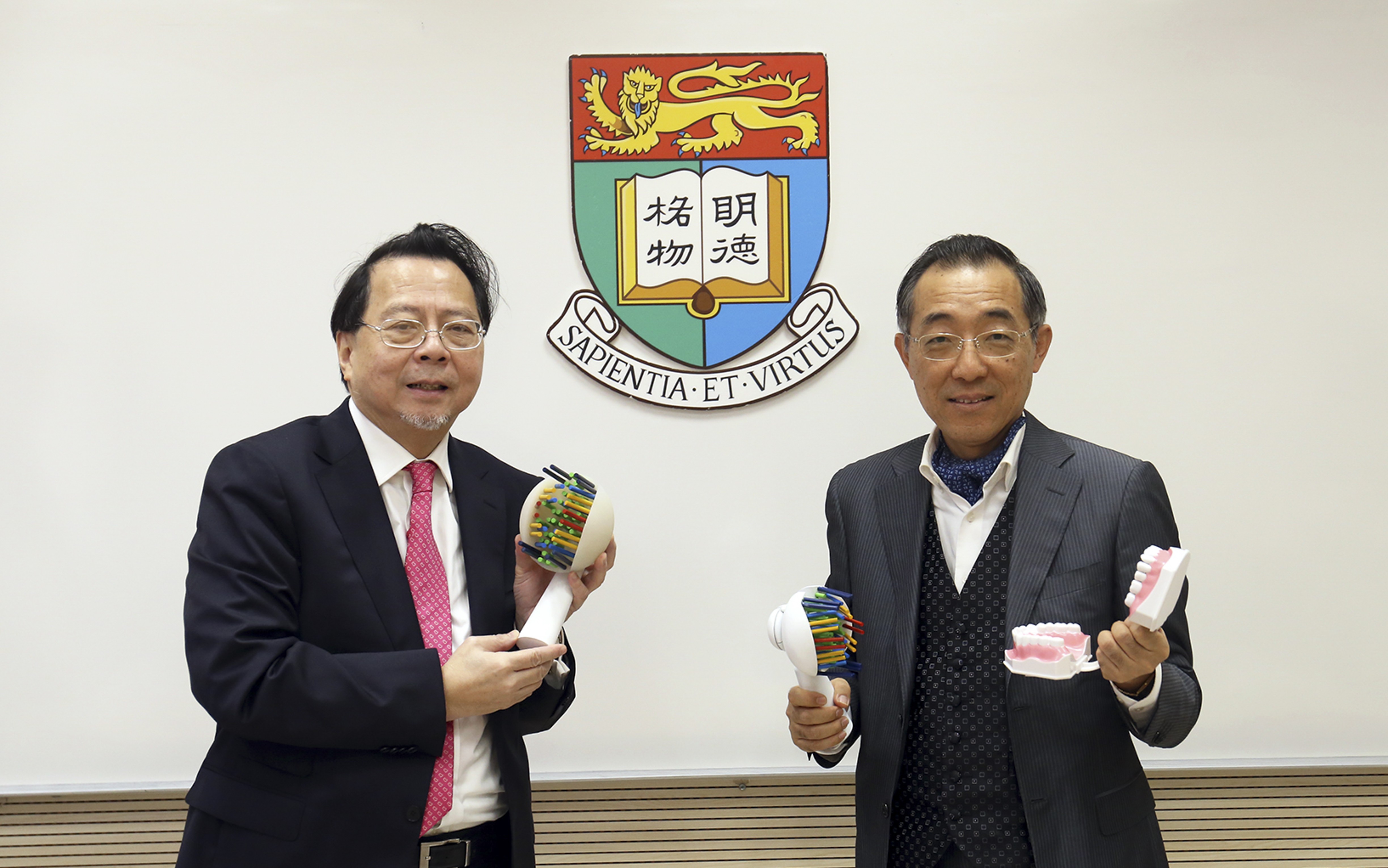 Dr Ng Tze-chuen (left) and Prof Jin Lijian showing enlarged models of their NJ Toothbrush. Photo: Handout