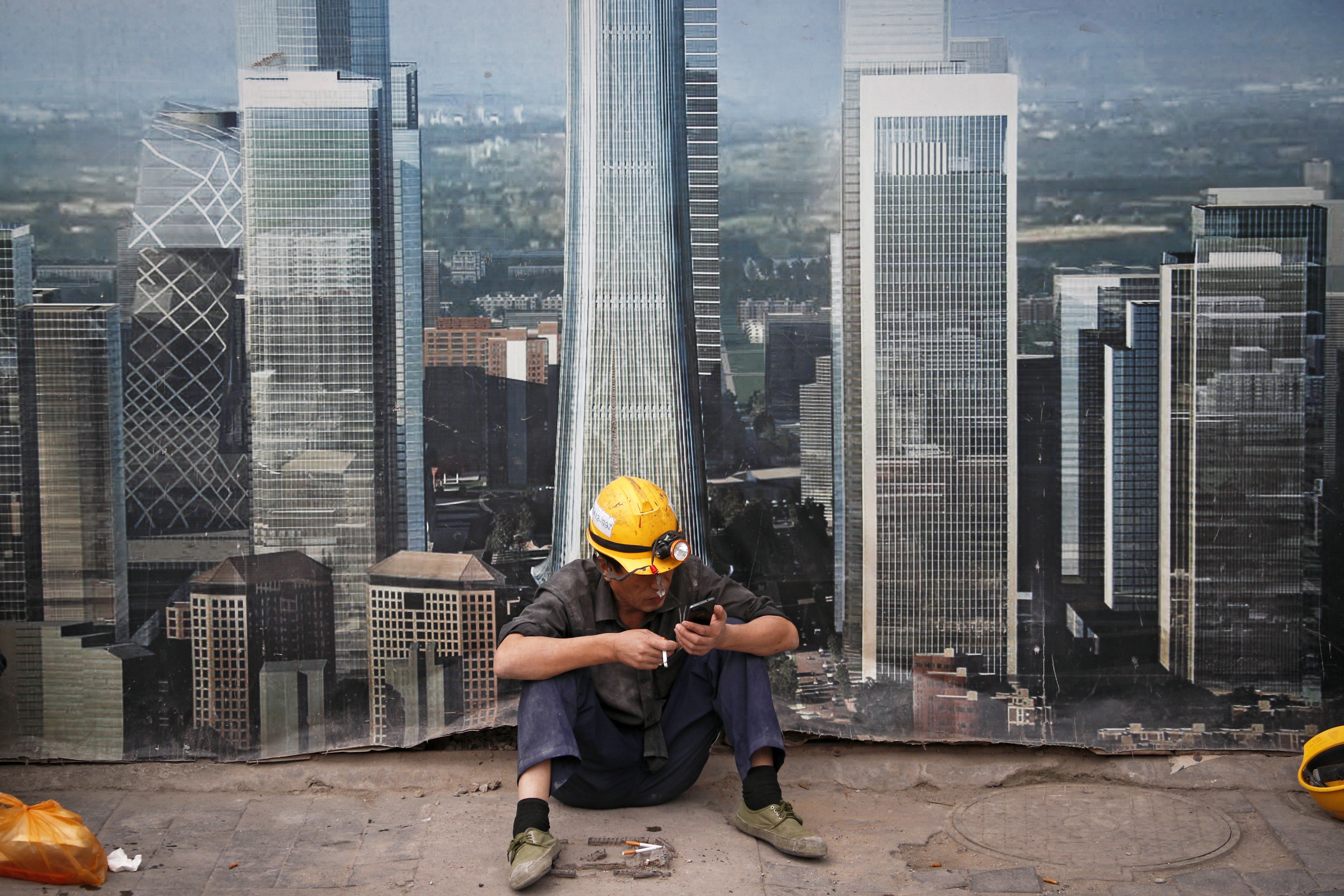 A worker takes a break outside a construction site in Beijing. The US-China trade war is likely to extend into the new year. The potential for further damage should help deter the countries from taking their threats too far. But the uncertainty from the trade tension may lead the world’s business community to consider restructuring global supply chains. Photo: AP