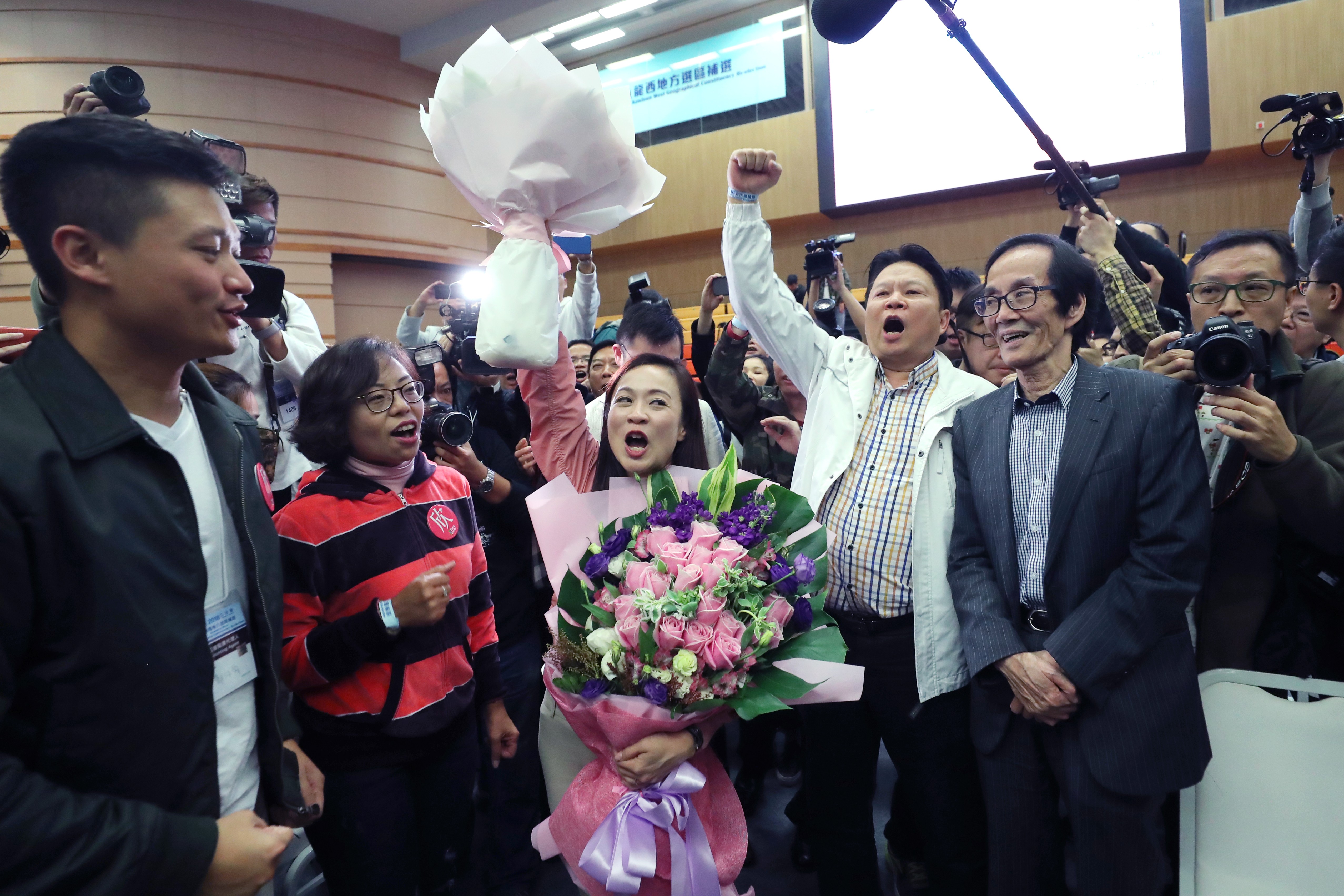 Lawmaker Vincent Cheng Wing-shun (left) and Alice Mak Mei-kuen (second left) celebrate Chan Hoi-yan’s (centre) victory. Photo: Sam Tsang
