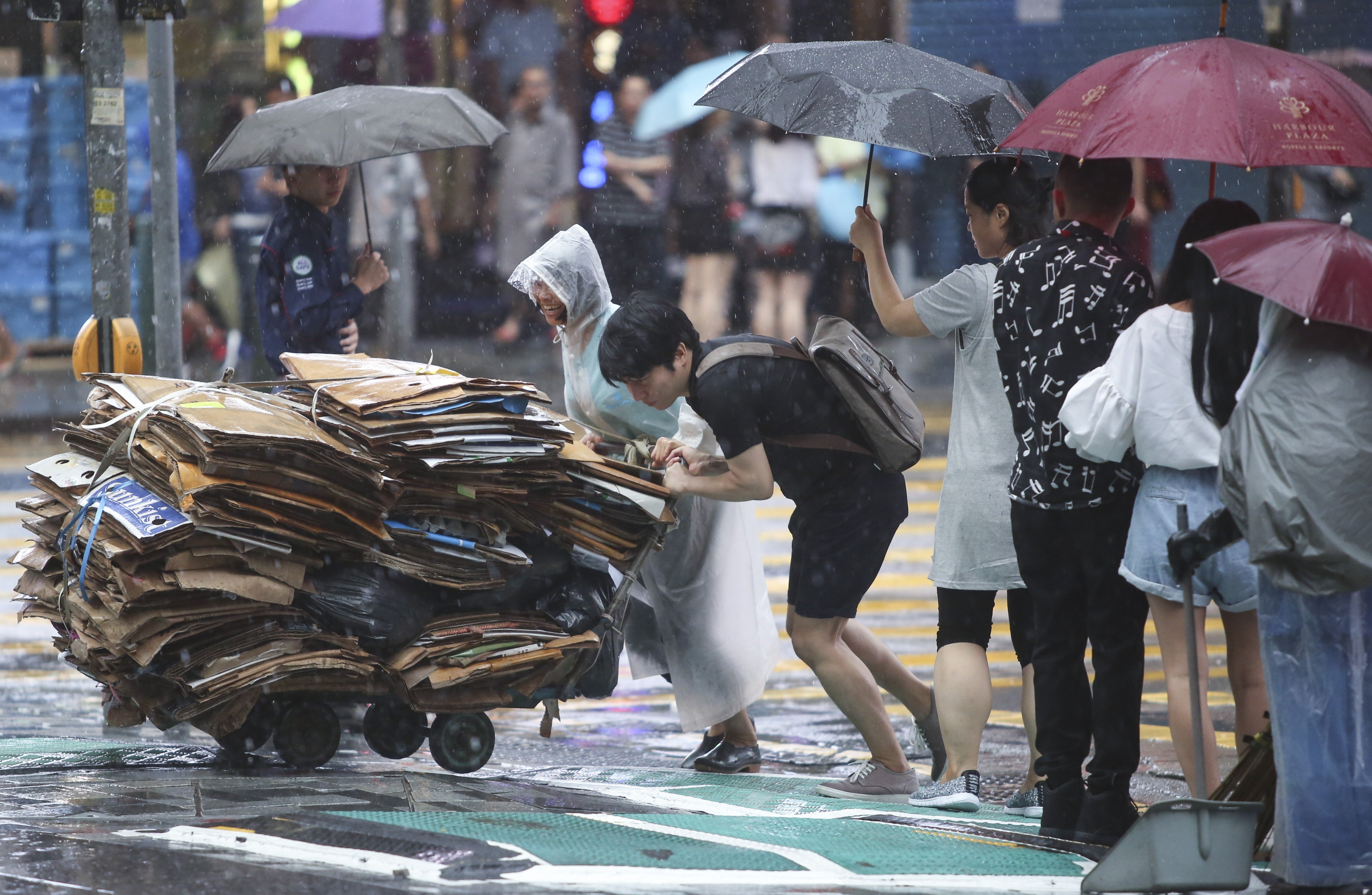 A young man helps an elderly woman push a trolley of cardboard sheets she collected for recycling during a rainy day in Hong Kong, in May 2017. A larger proportion of Hong Kong’s elderly than its working-age population live in public housing, a fact not reflected in the city’s poverty line calculations. Photo: Sam Tsang