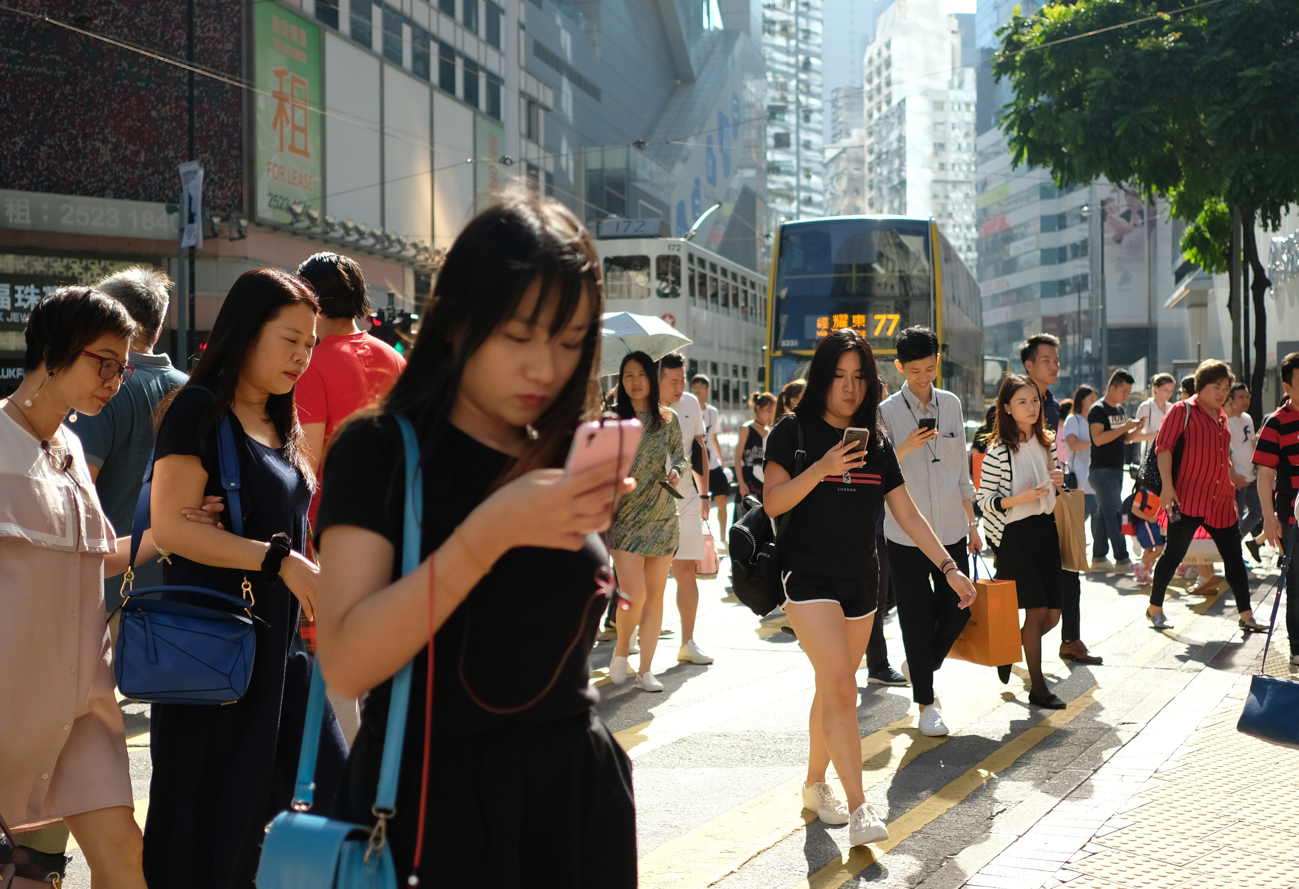Pedestrians view their smartphones as they walk cross an intersection in Hong Kong’s Causeway Bay shopping district. Photo: Fung Chang