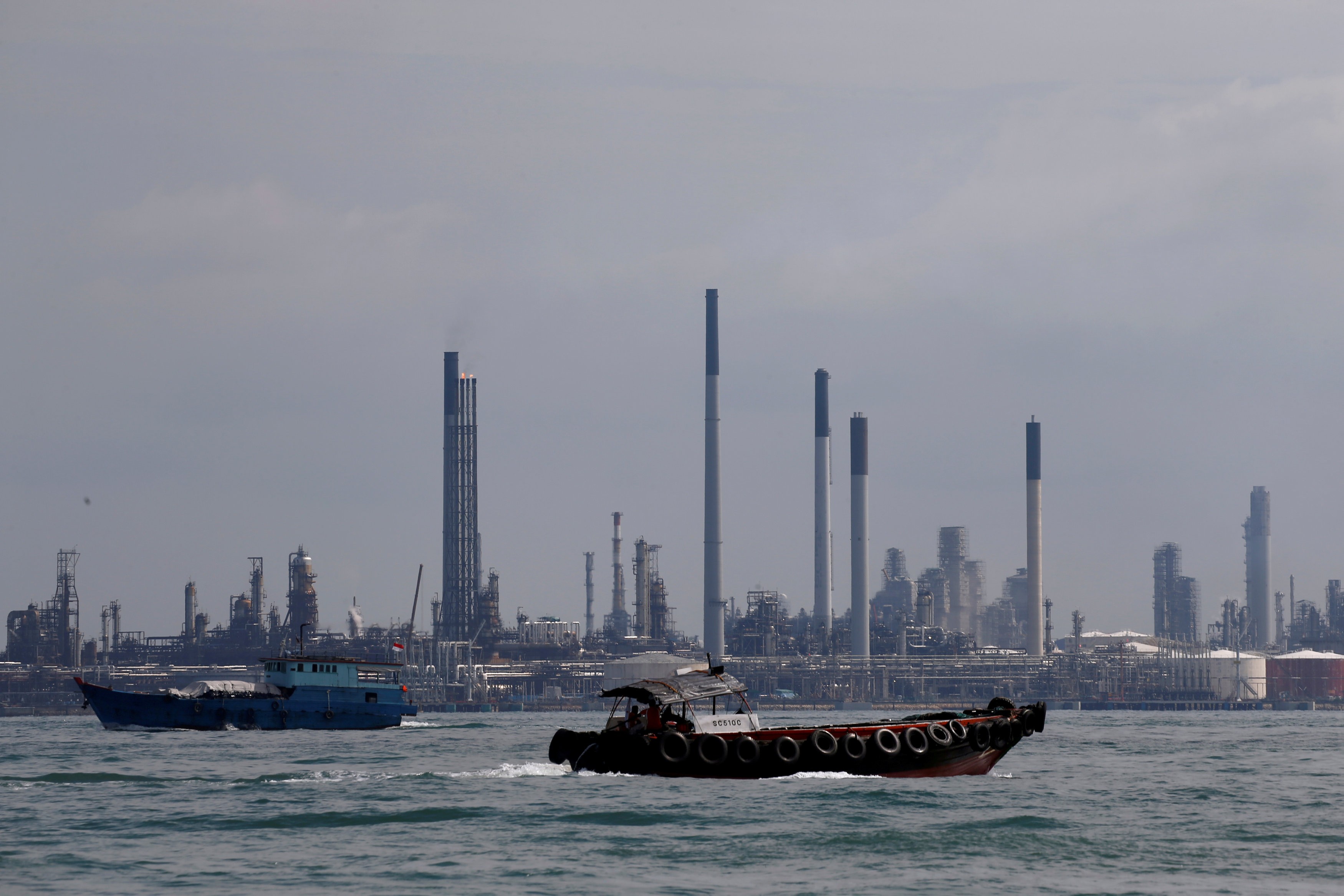 Boats sail past Pulau Bukom oil refinery along the southern coast of Singapore, where thieves made off with US$150 million worth of gas oil. Photo: Reuters