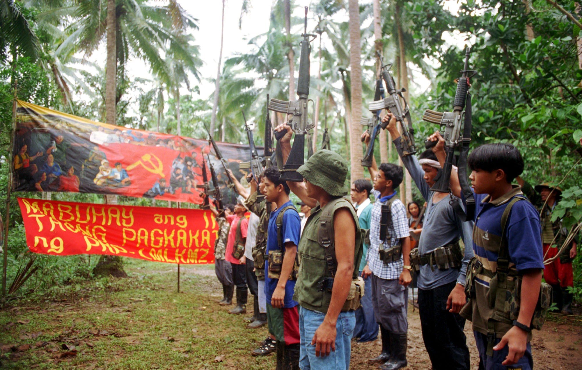 New People's Army guerillas raise their firearms to mark a previous anniversary in 1998. Photo: AP