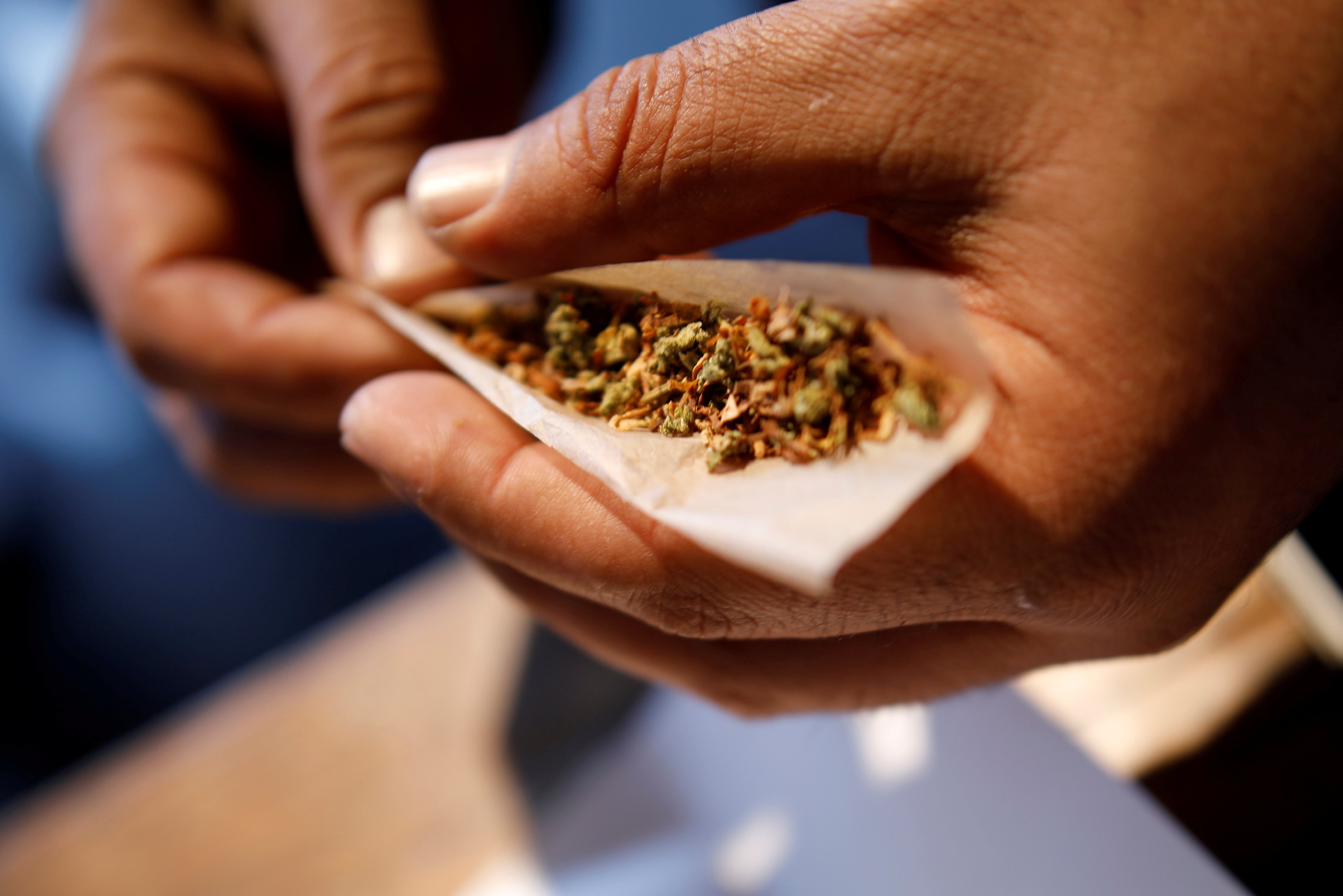 A man prepares a mix of tobacco and marijuana for smoking. Photo: Reuters