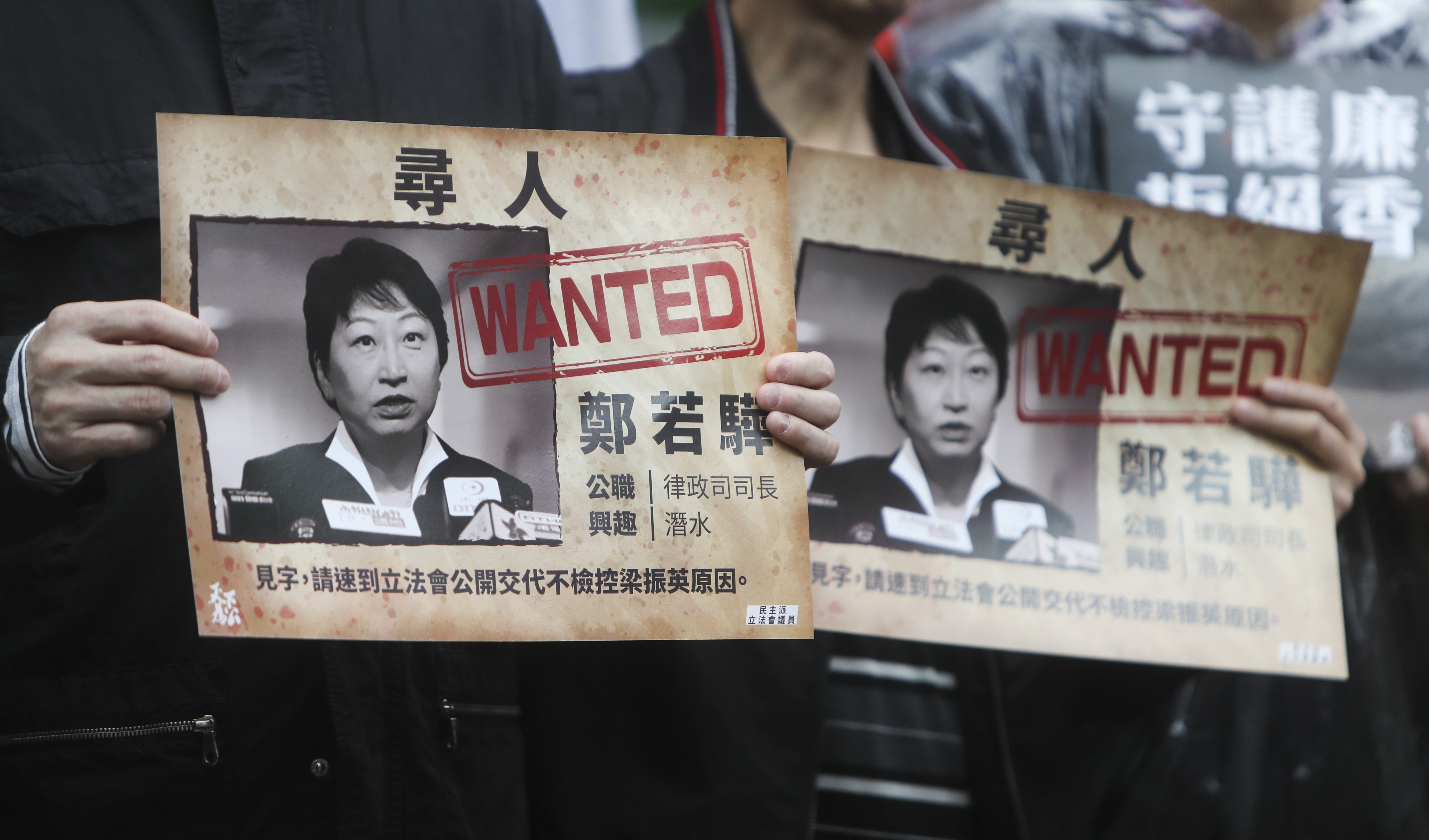 Protesters hold up placards picturing Secretary for Justice Teresa Cheng at a rally on December 23, calling on the minister to explain the justice department’s reasons for not prosecuting former chief executive Leung Chun-ying over the UGL payment. Photo: Winson Wong