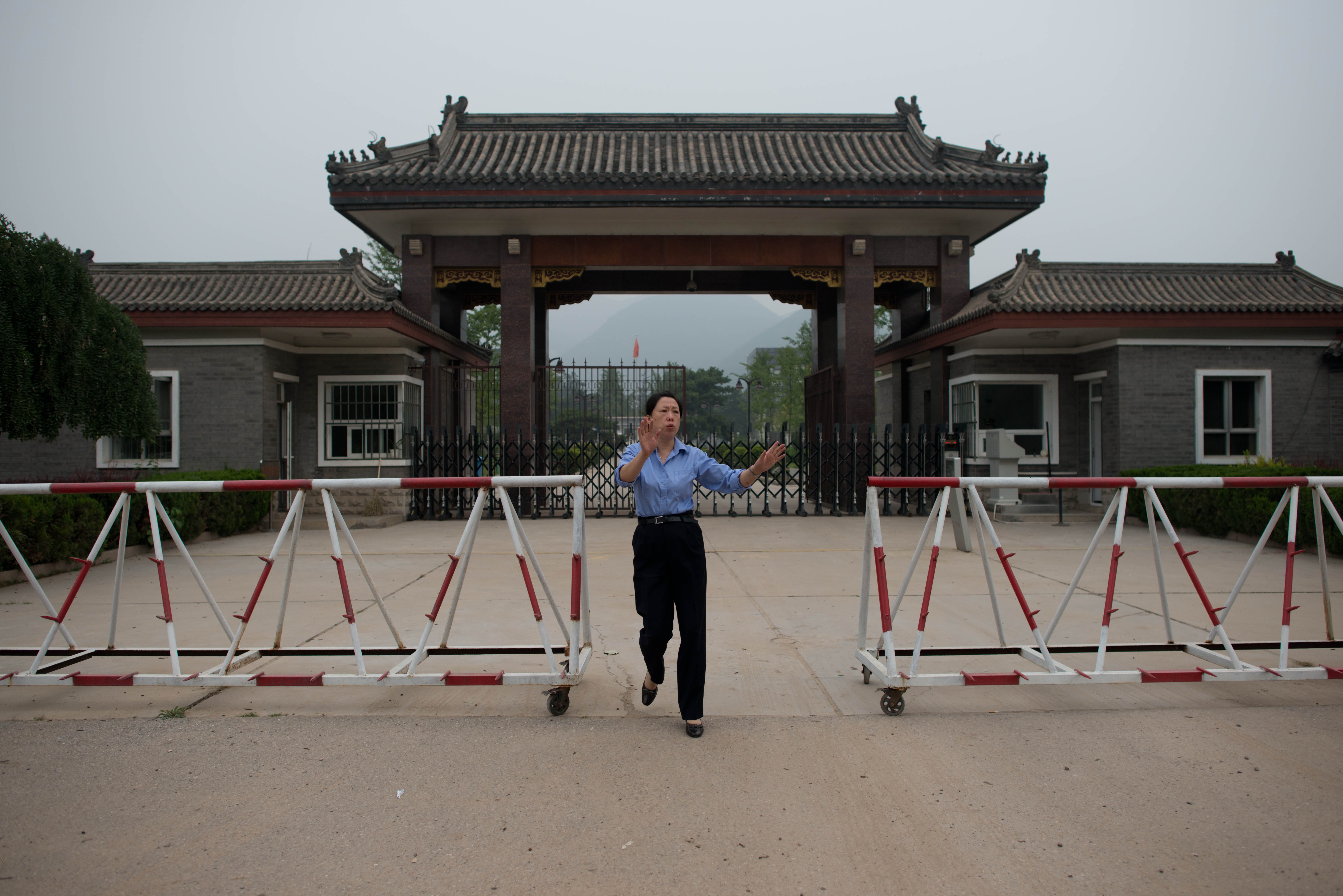 A policewoman tries to stop media from taking photos at the entrance to Qincheng prison. Many of the inmates at the maximum security jail are household names in China. Photo: AFP