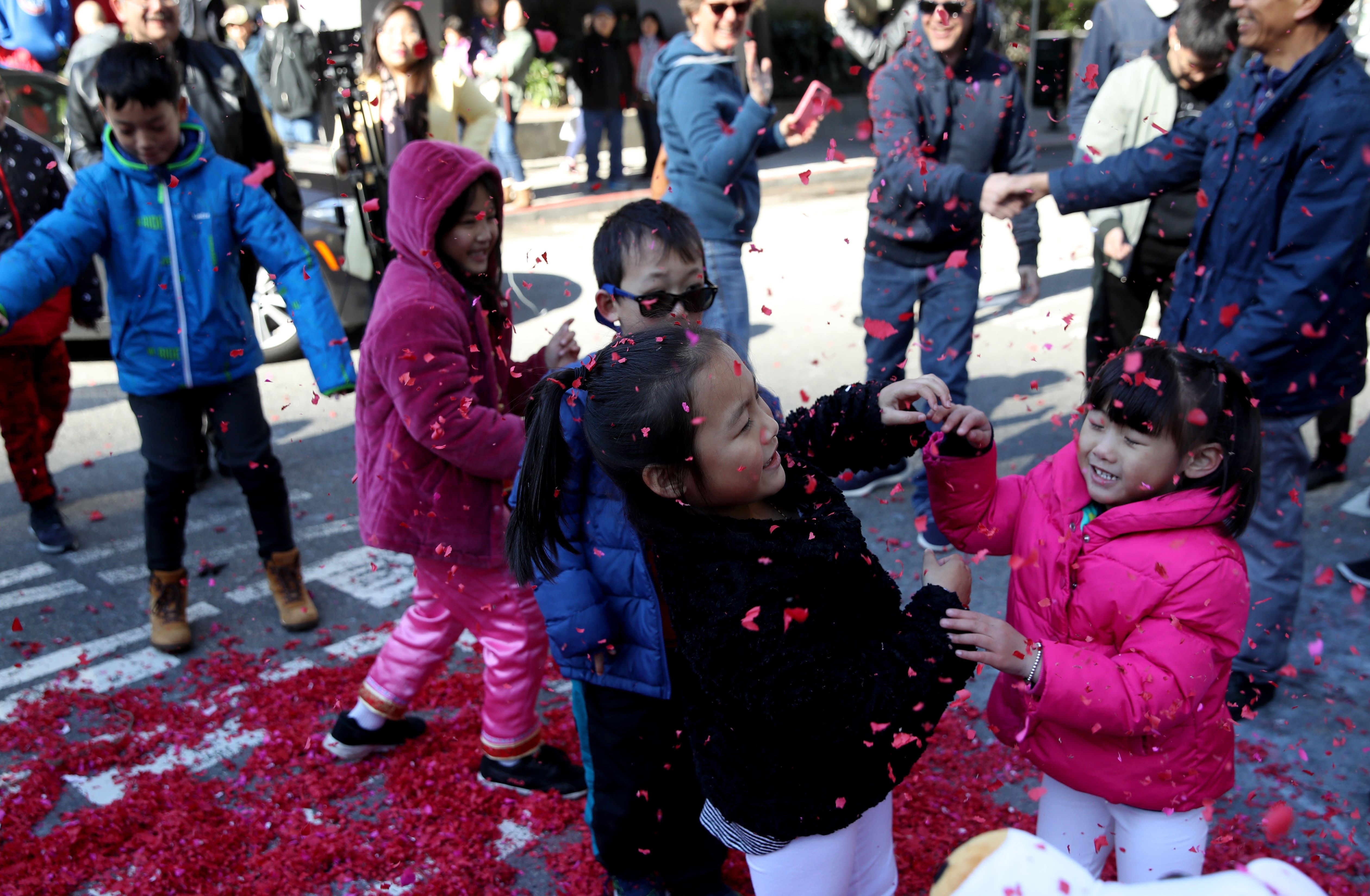 Children play with exploded firecracker wrappers while ushering in Lunar New Year, on Tuesday, in San Francisco, California. San Francisco will have a month-long celebration as part of the Year of the Pig. Photo: Getty Images/AFP