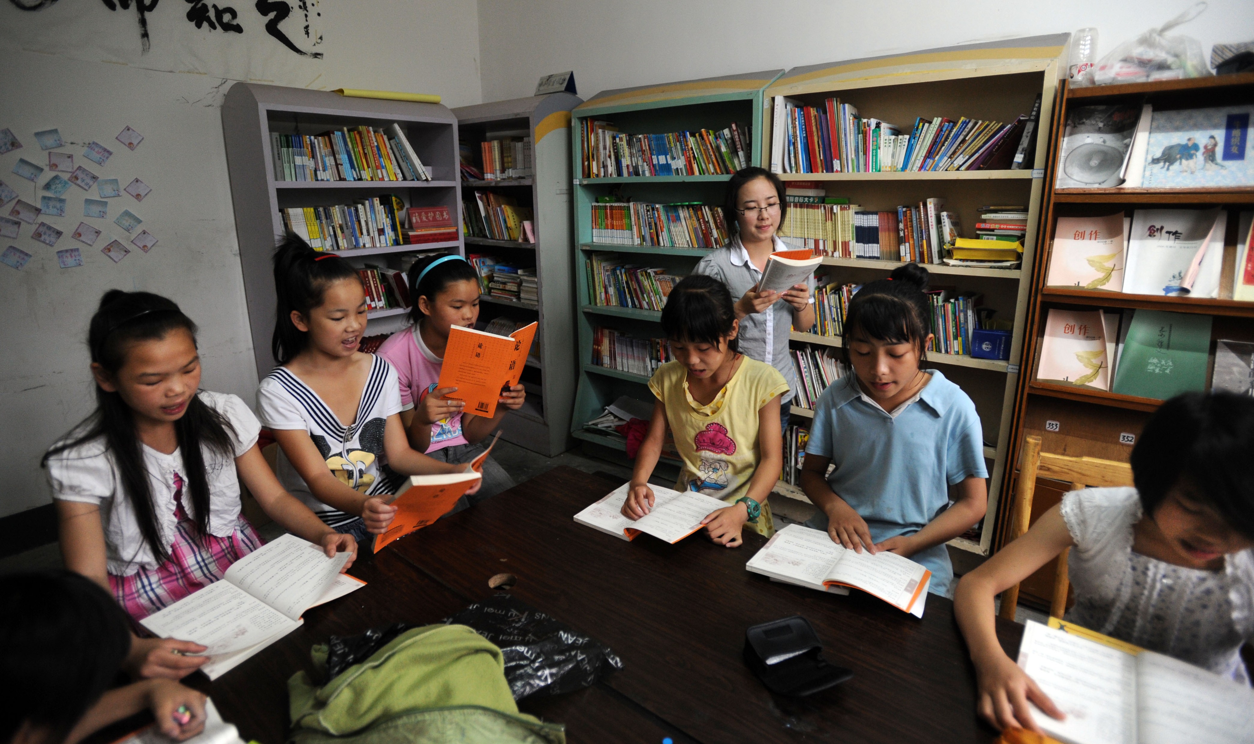A volunteer who is a student from a local university teaches children at the Farmhouse School in Longdong village, Changsha city, China. Photo: Handout