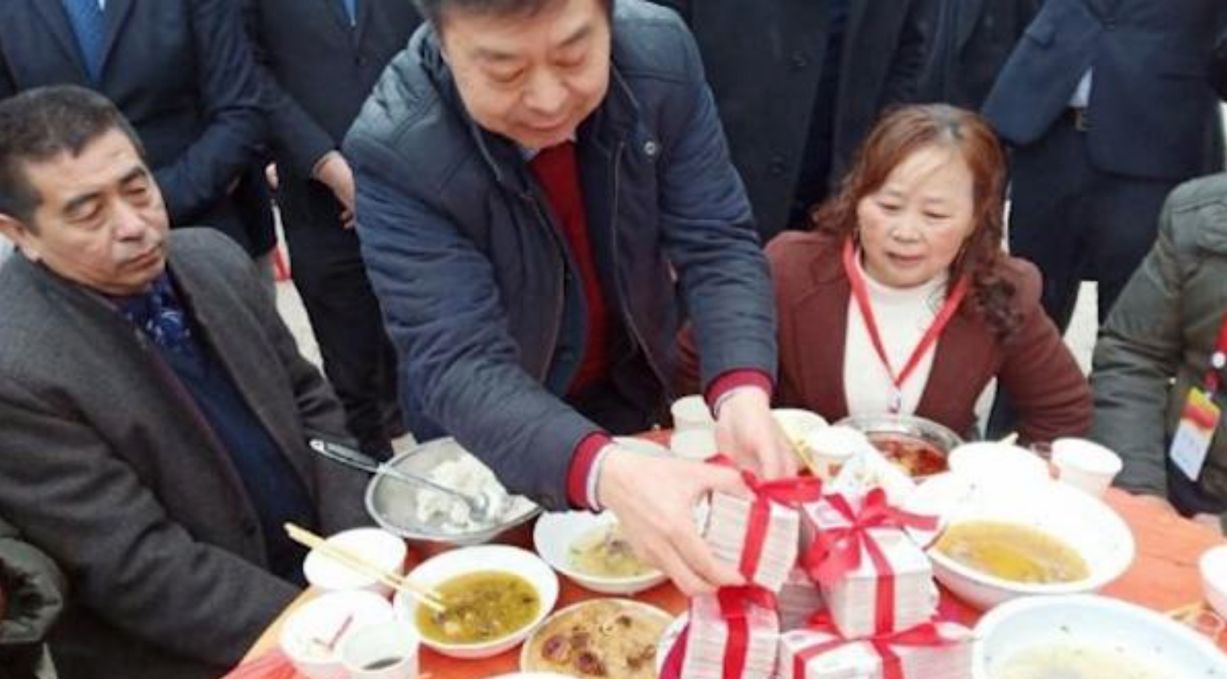 Tycoon Zheng Daqing hands over bundles of cash to the residents of the Sichuan village in which he was born. Photo: Thepaper.cn