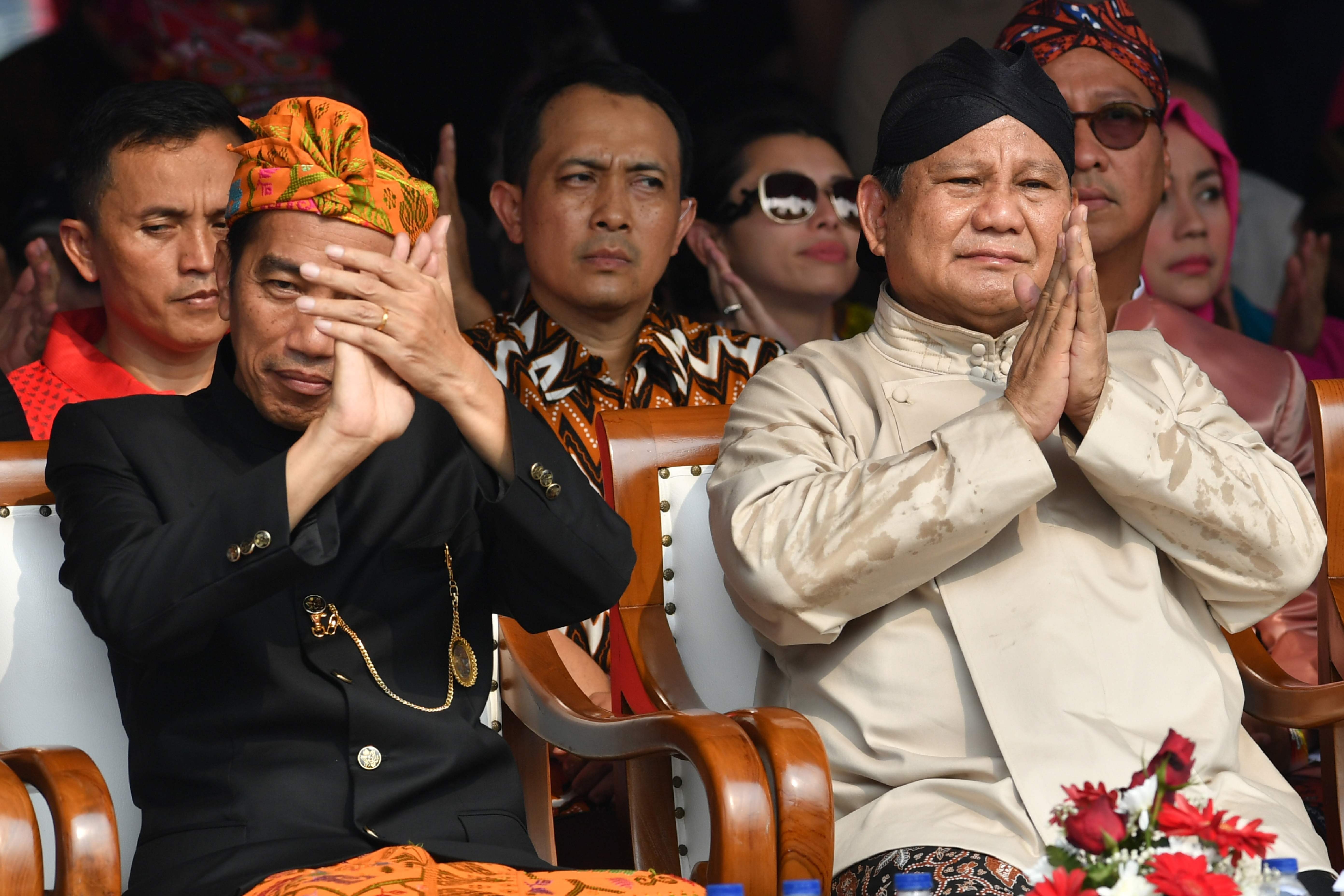 Indonesian President Joko Widodo (left) and his opponent in the presidential race, Prabowo Subianto, applaud at an event to kick off campaigning for the 2019 general election at the National Monument in Jakarta on September 23, 2018. Photo: AFP