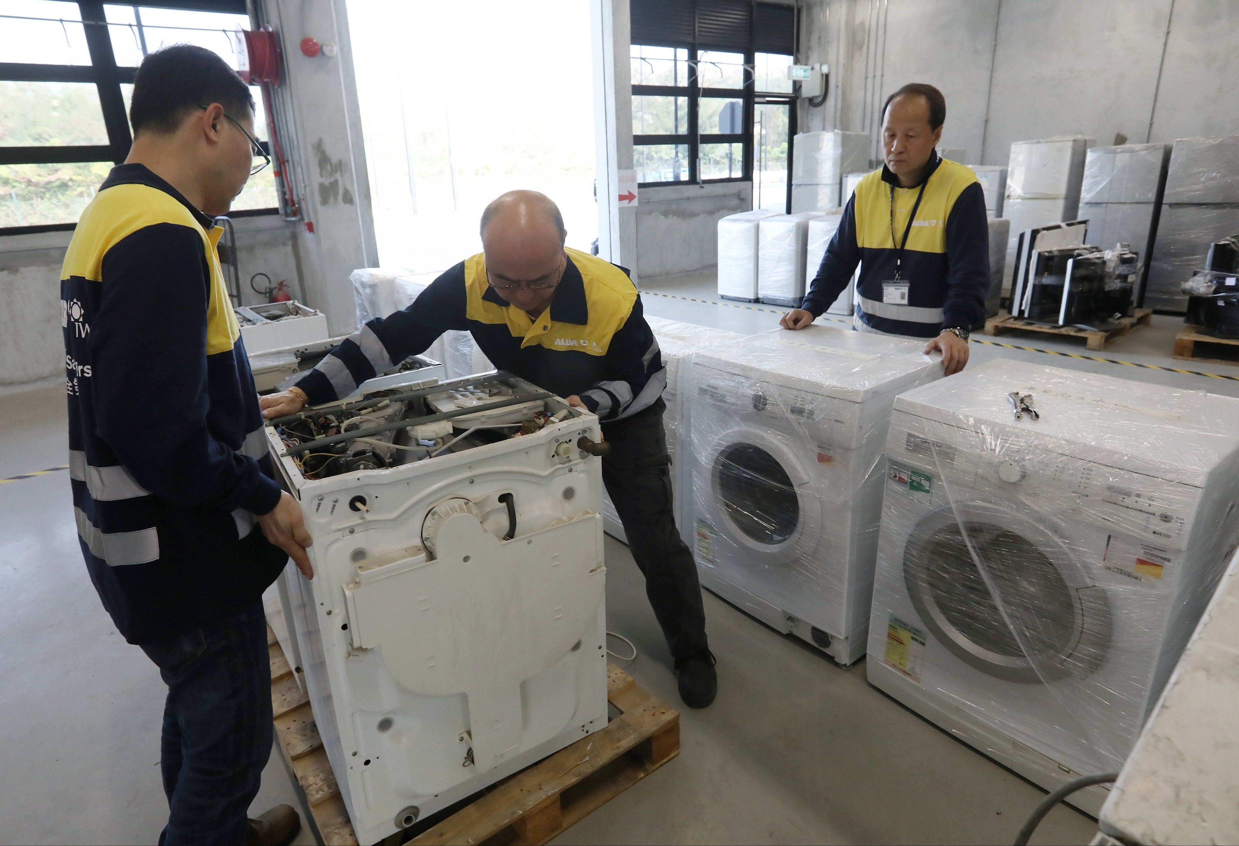 Staff at the recycling plant working on discarded washing machines. Photo: Edward Wong