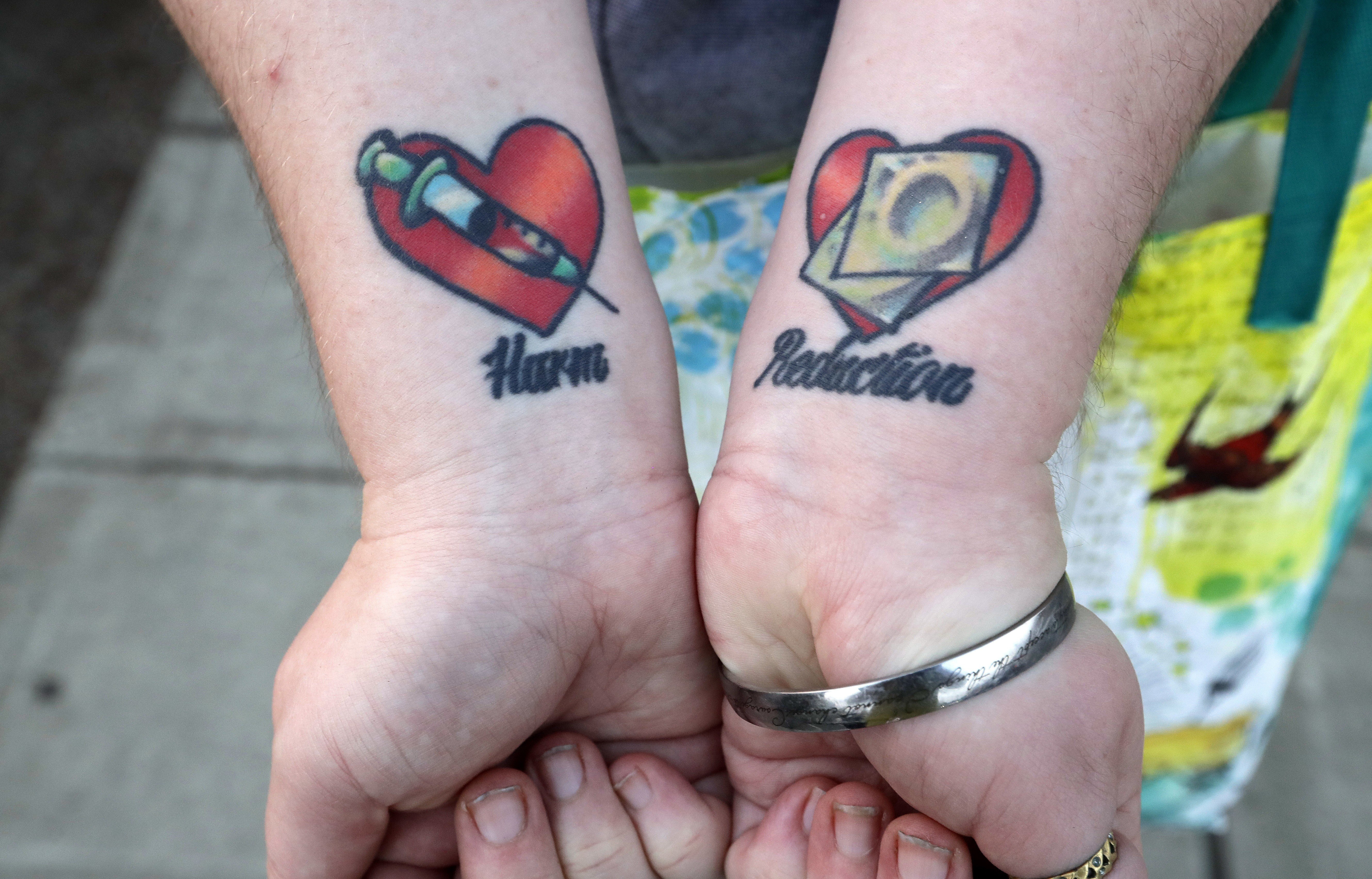 A former sex worker and trafficking survivor shows her tattoos on her forearms that read “harm reduction”. Leaving the industry in the hands of criminals and the black market only perpetuates violence against women and the degradation of sex workers. Photo: AP