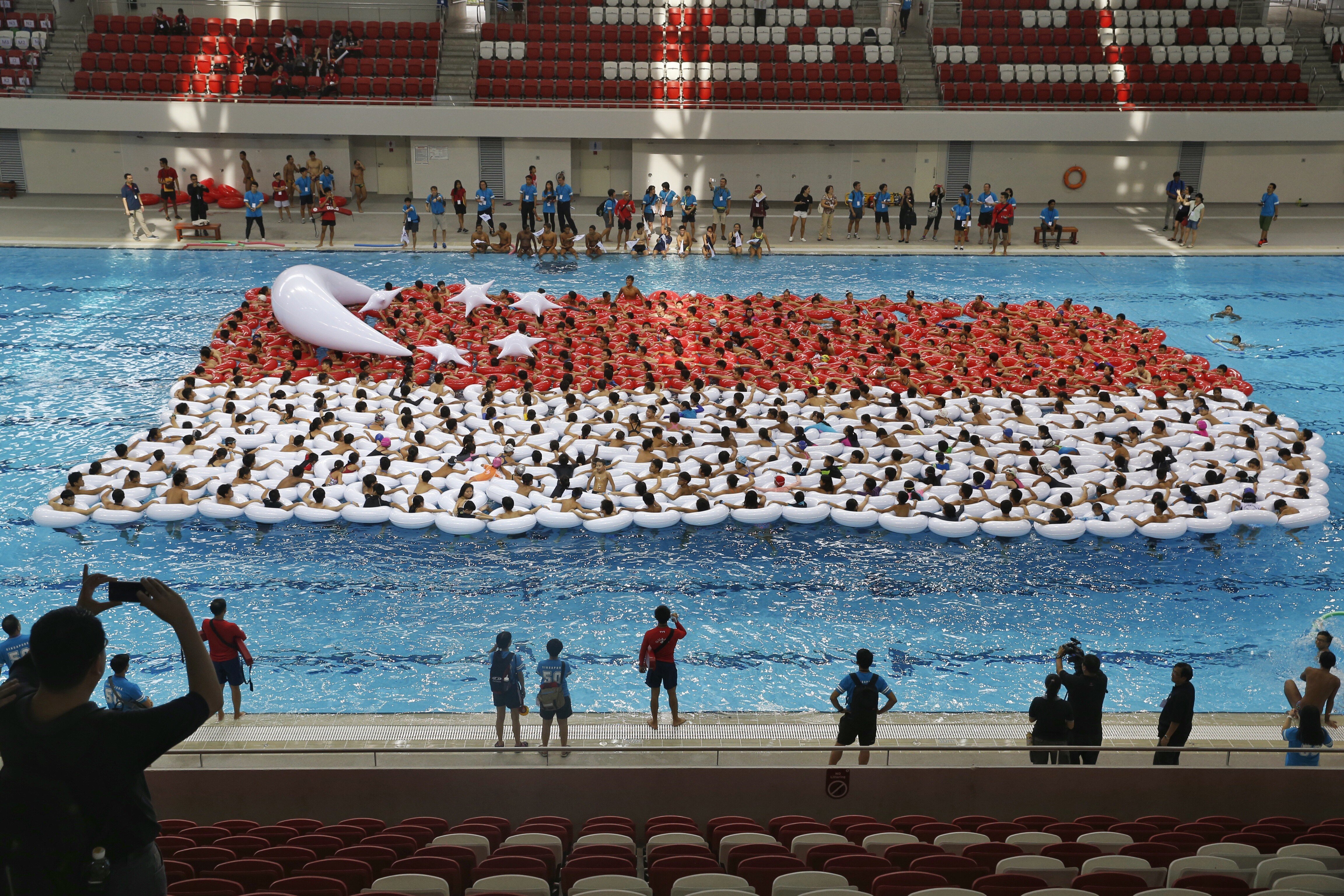 Students from primary, secondary and post-secondary schools attempt to form the largest floating Singapore flag in 2015. The Singaporean school curriculum includes extracurricular programmes to enhance students’ all-round development. Photo: The Straits Times