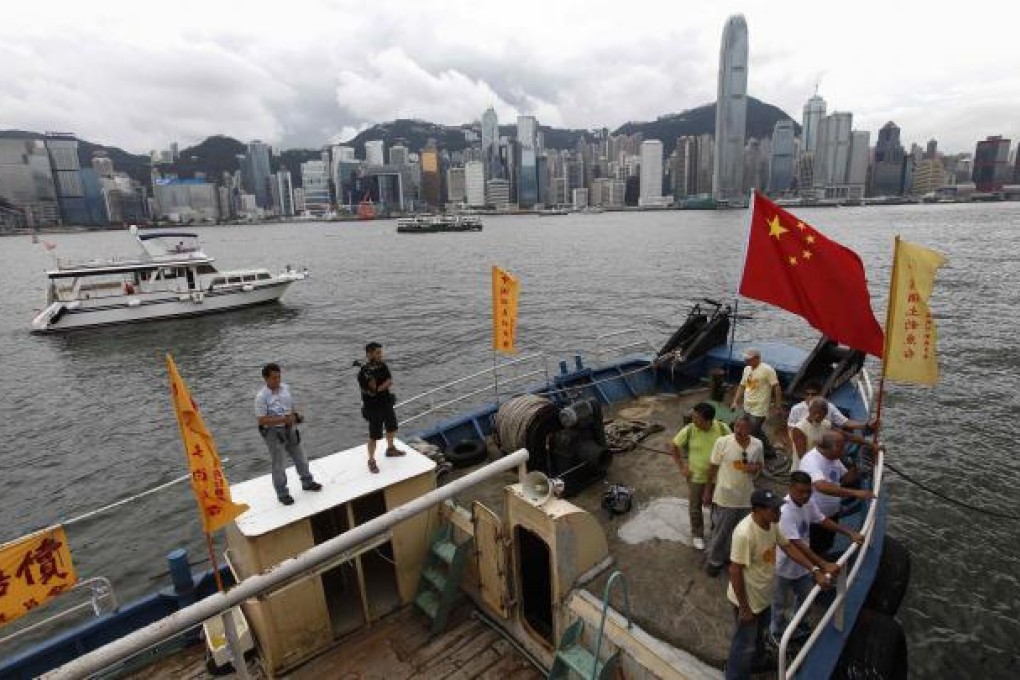 Activists from the Hong Kong-based "Action Committee for Defending the Diaoyu Islands" shout slogans and wave the Chinese flag on a fishing boat before departing for the disputed islands Senkaku in Japan, or Diaoyu in China, in Hong Kong August 12, 2012. The event was held to protest against some 50 Japanese lawmakers planning to visit the islands on August 18, local media reported. REUTERS/Tyrone Siu
