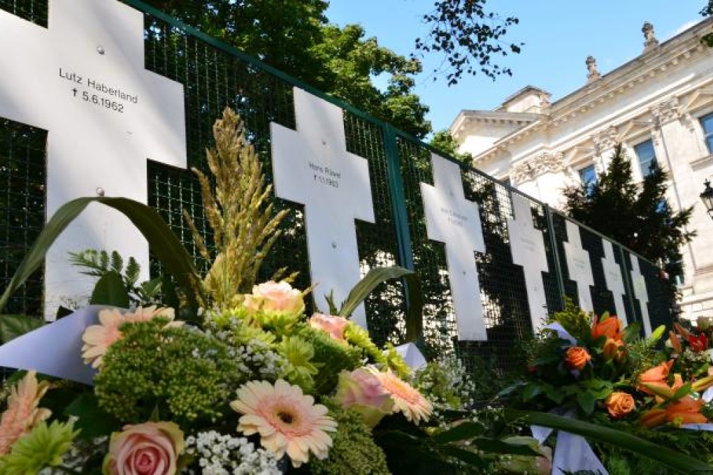 Flowers are placed in front of symbolic crosses commemorating the victims of the Berlin Wall's border guards, in Berlin, Germany, 13 August 2012. EPA/SEBASTIAN KUNIGKEIT
