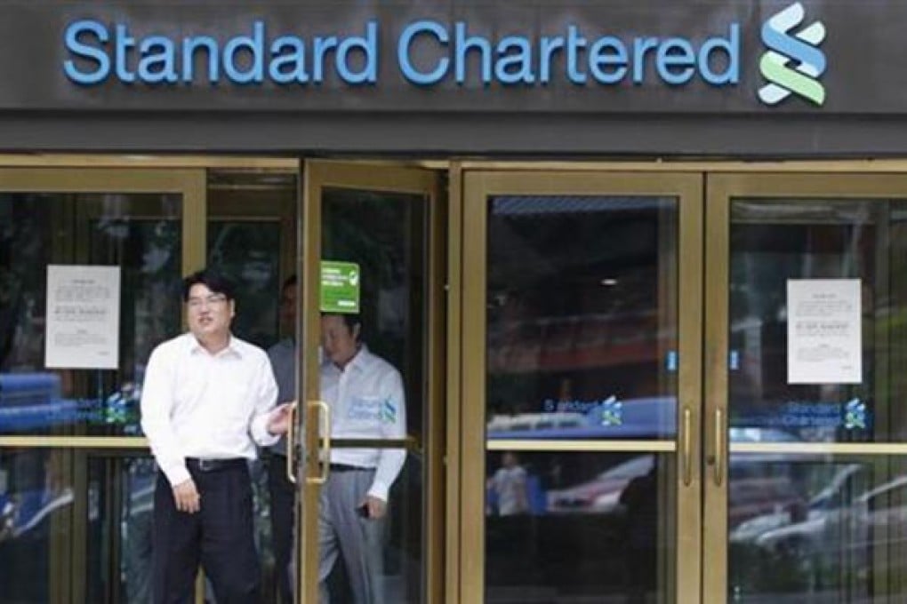 Employees of Standard Chartered leave a branch of the bank in central Seoul August 9, 2012. REUTERS/Lee Jae-Won