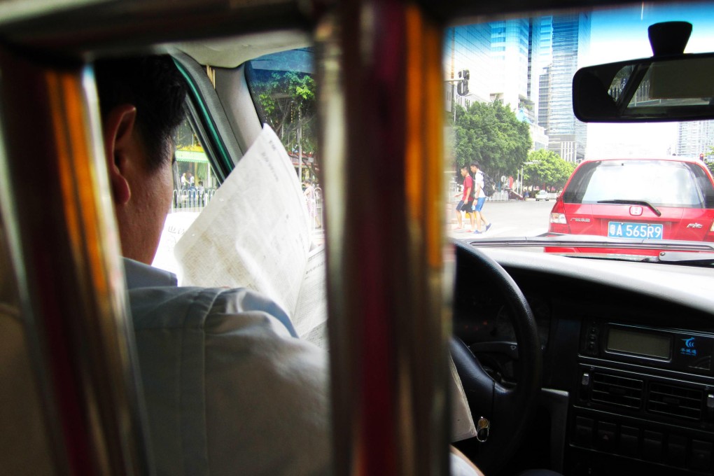 Driven to distraction:A taxi driver catches up on the day's news at 60km/h.