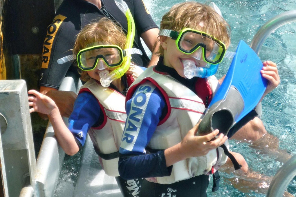 Michael, Tilly and Sam at the Great Barrier Reef. They believe if you want to see the best of Australia, you have to take the plunge.Photo: Helen Leavey