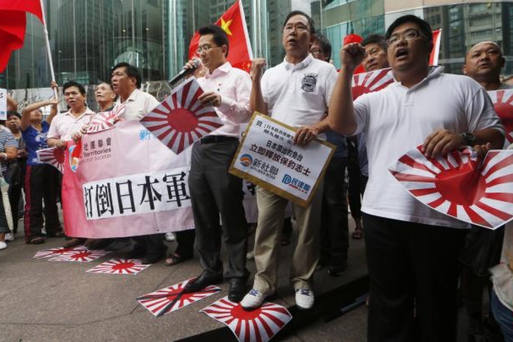 Anti-Japan protesters step on mock Japanese Rising Sun Flags during a rally outside the Japanese Consulate General in Hong Kong Thursday Aug. 16, 2012. AP Photos