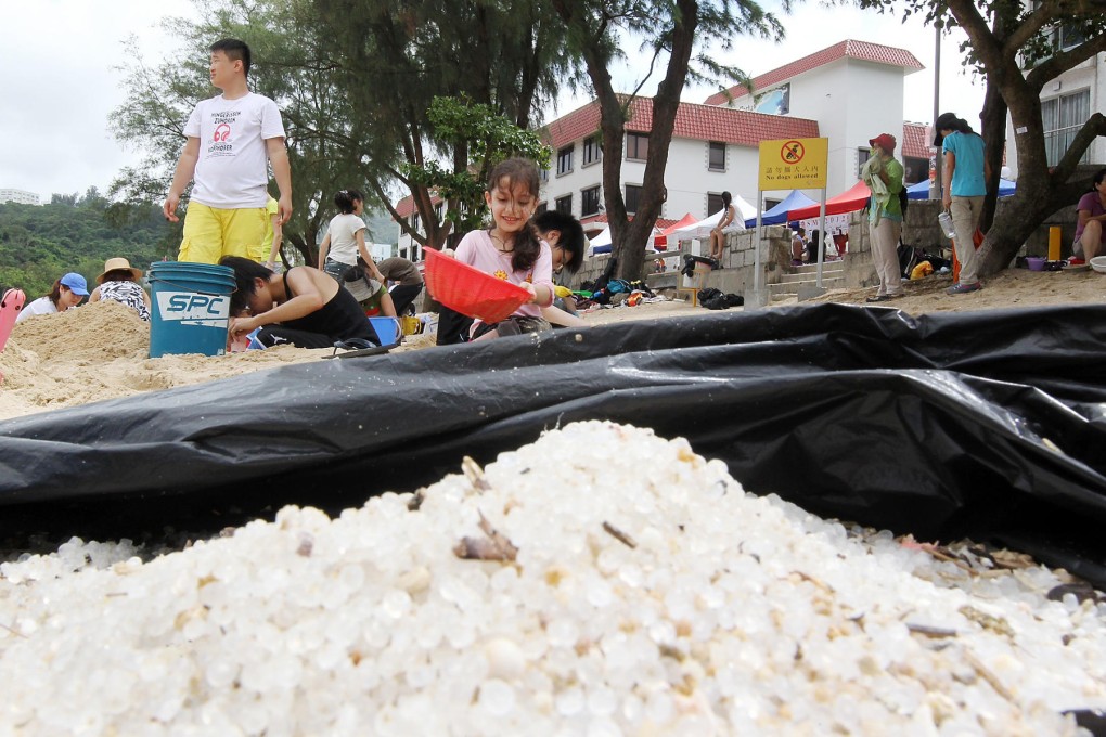 Volunteers collect pellets that were gathered from Silver Mine Bay Beach on Lantau. About 300 volunteers joined the clean-up yesterday.Photo: K.Y.Cheng