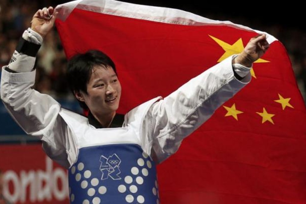 China's Wu Jingyu celebrates with a national flag after winning her women's -49kg gold medal taekwondo match against Spain's Brigitte Yague Enrique during the London 2012 Olympic Games. Photo: Reuters
