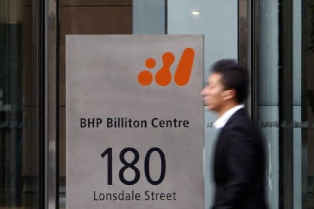 File photo of a man walking past the head office of BHP Billiton in central Melbourne. MICK TSIKAS/REUTERS