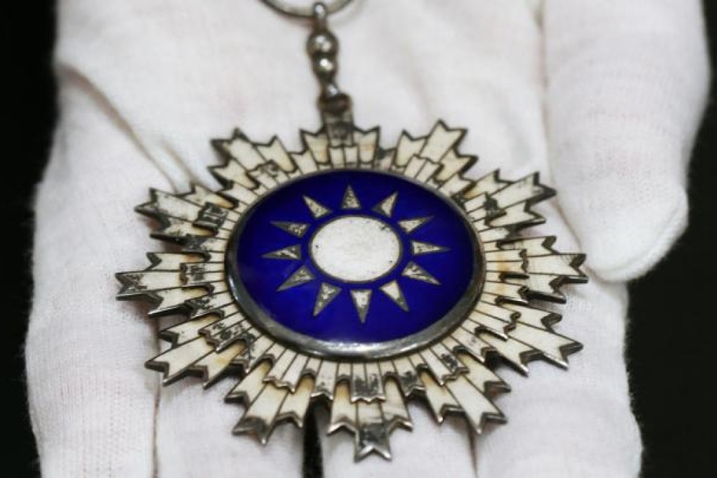 Chuk Hong-ming holds the medal for sale. Photo: Sam Tsang