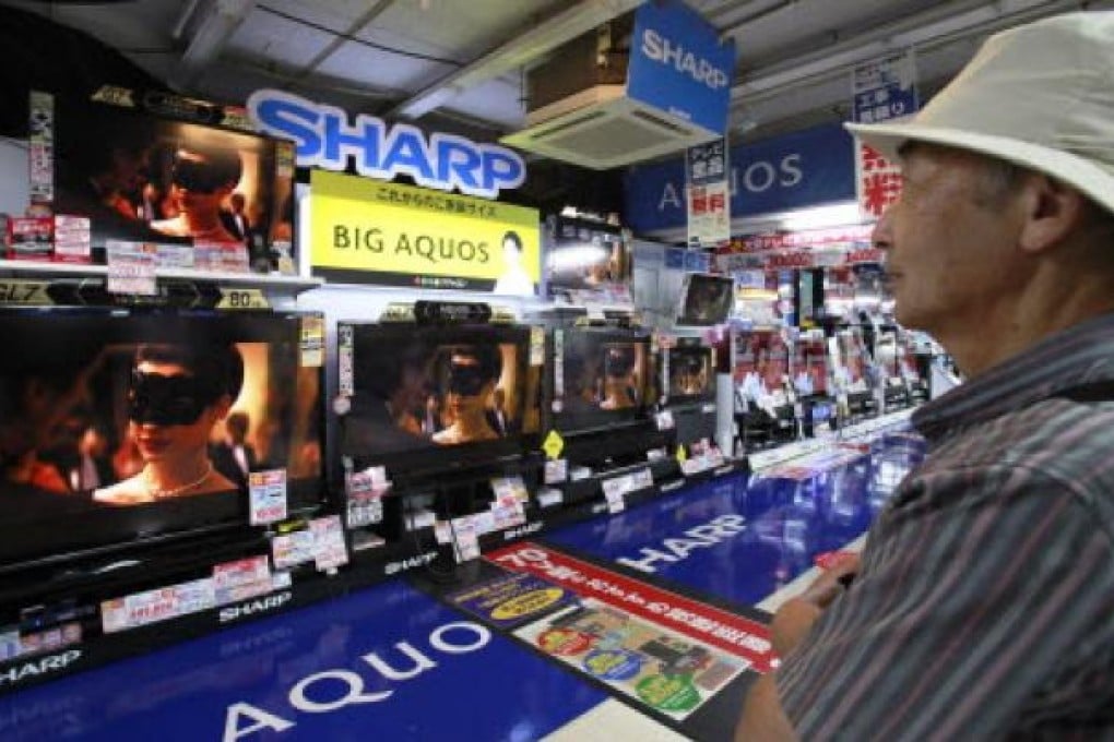 A man looks at Sharp Corp's Aquos TVs in a Tokyo shop in this August 8, 2012 file photograph. REUTERS/Yuriko Nakao