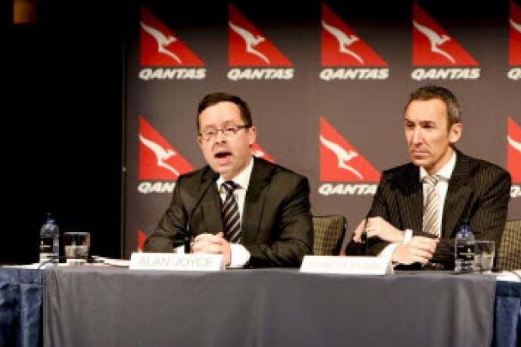 epa03367699 Qantas CEO Alan Joyce (L) speaks as CFO Gareth Evans (R) looks on during the Qantas Group full year profit results announcement in Sydney, Australia, 23 August 2012. Qantas Airways Ltd said it would cancel firm orders for 35 Boeing 787-9 aircraft after posting a loss for the year ending June of 245 million Australian dollars (257 million US dollars). Australia's biggest carrier said high fuel prices and an industrial dispute that temporarily grounded its fleet were reflected in a switch from a profit of 250 million Australian dollars in the previous 12-month period. Nicholas Welsh/EPA
