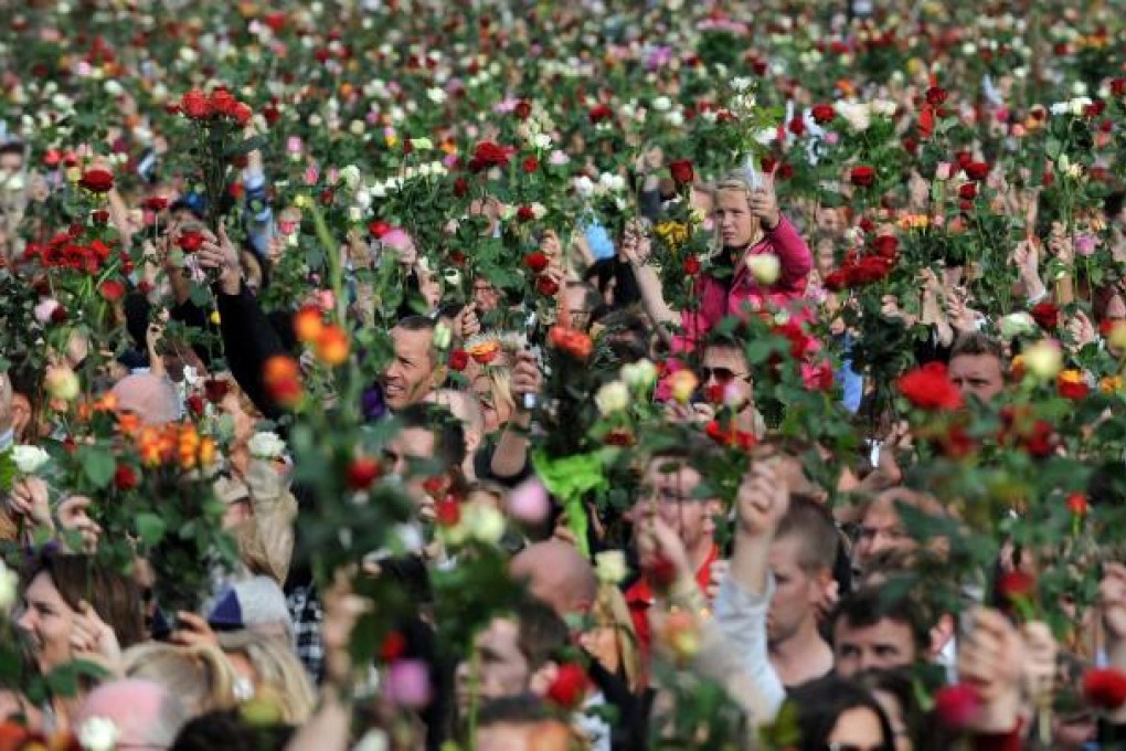 Thousands hold roses in a march in Oslo last year. Photo: EPA