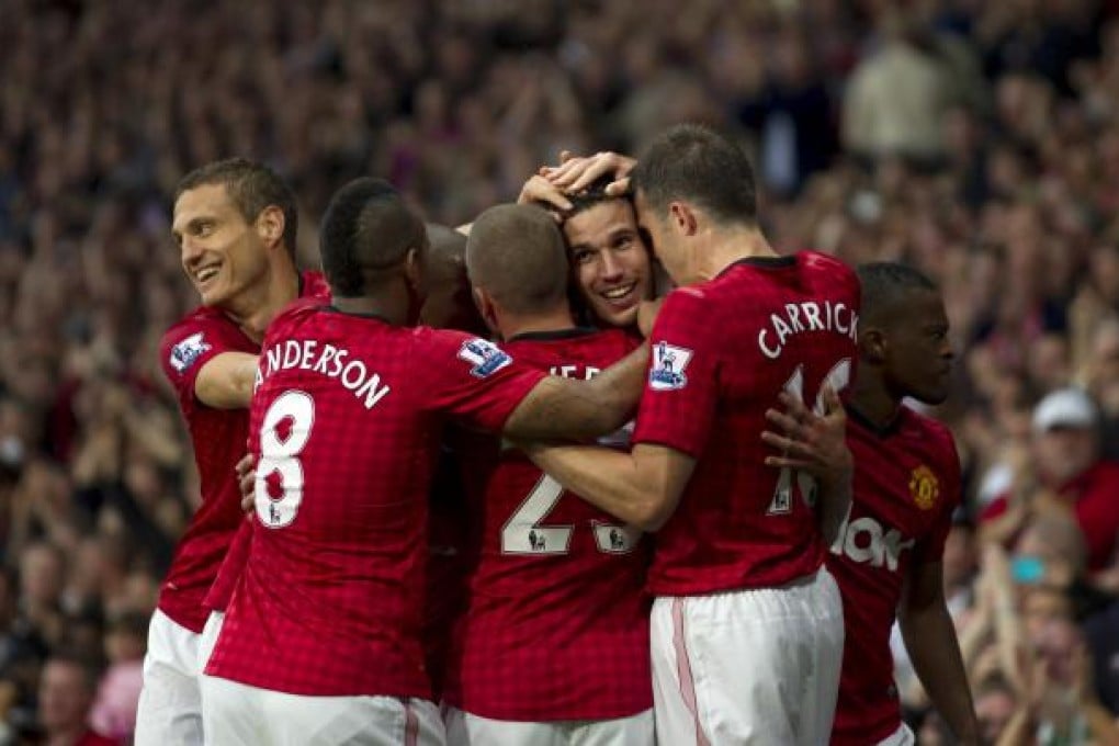 Robin van Persie (centre right) is mobbed by his new teammates after scoring his first goal for Manchester United against Fulham yesterday. Photo: AP