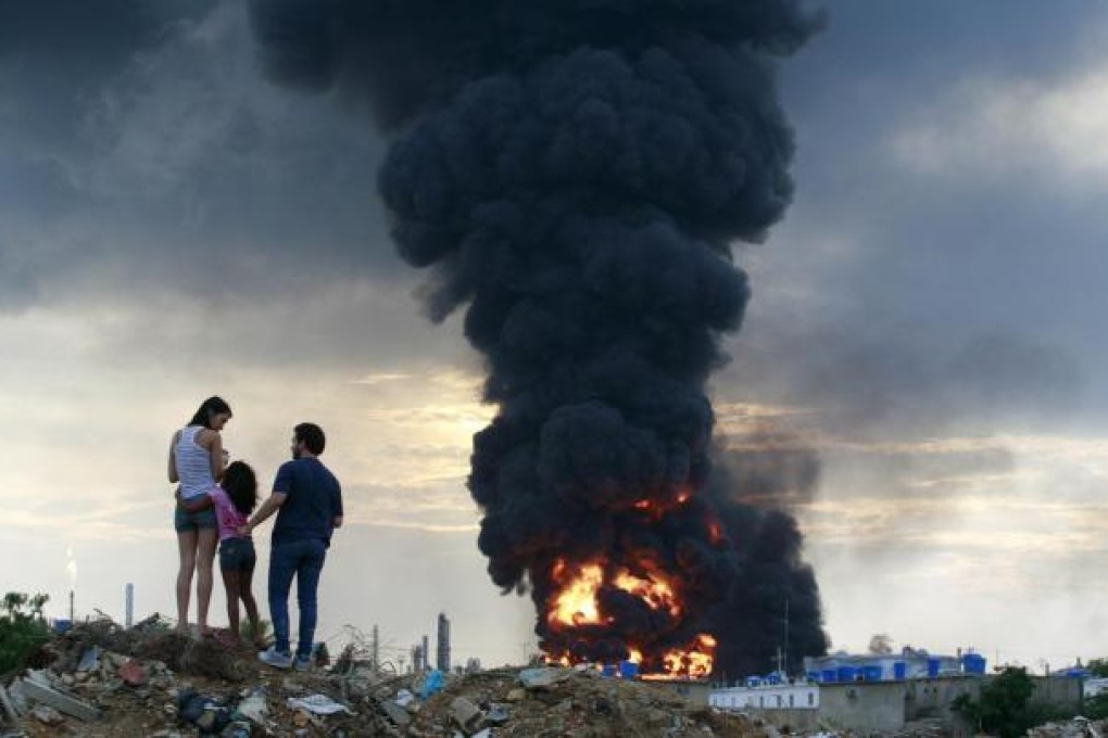 A family watches the blaze after an explosion at the Amuay oil refinery in Venezuela. Photo: Reuters