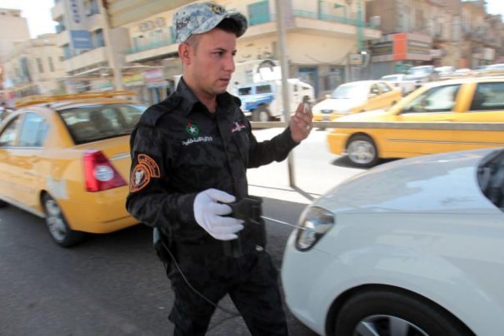 An Iraqi security officer holds an ADE 651 bomb detector device, believed to be virtually useless, at a checkpoint in Baghdad. Photo: AFP