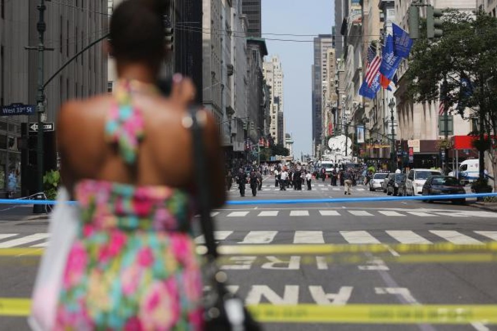 A woman takes photos of the scene of a shooting outside the Empire State Building on Fifth Avenue August 24, 2012 in New York City. Mario Tama/Getty Images/AFP