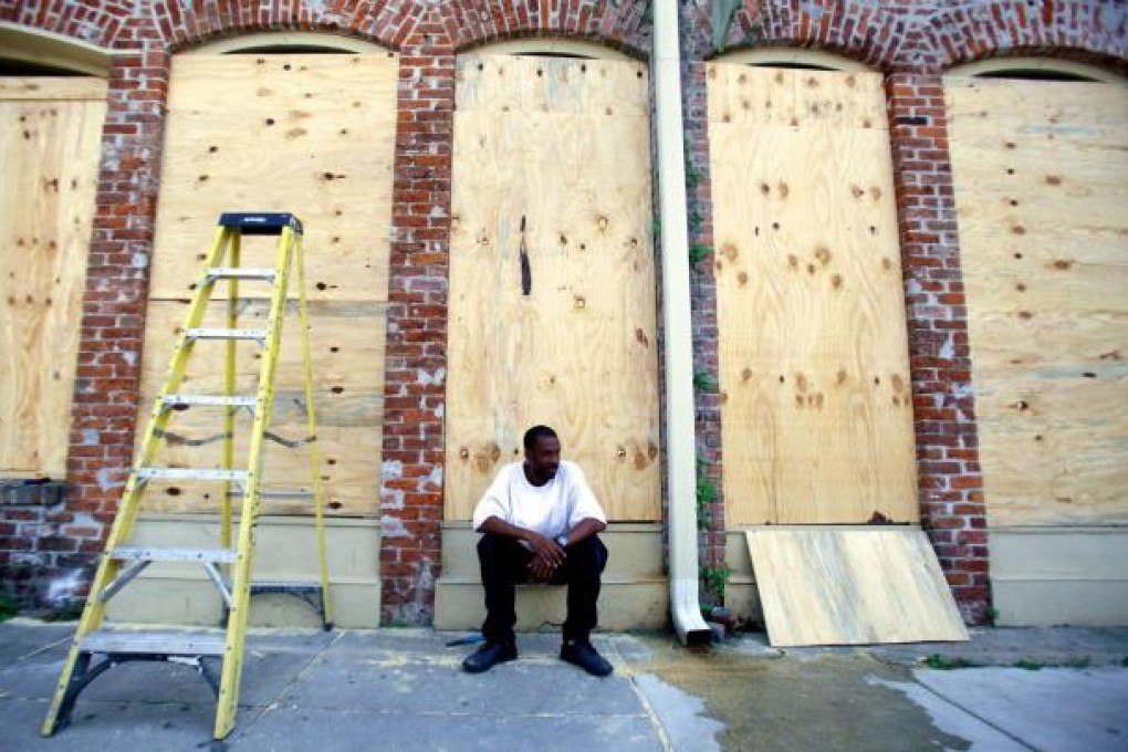 James Cardoza takes a break after helping his boss board up the windows of his business as Tropical Storm Isaac neared New Orleans yesterday. Photo: Reuters