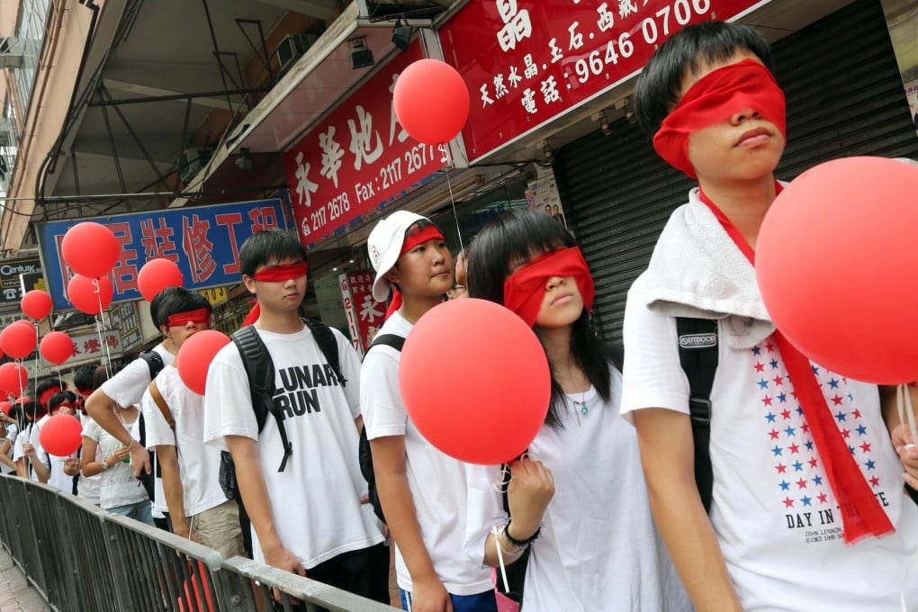 Students protesting against national education wear red blindfolds and carry red balloons in Shau Kei Wan. Photo: David Wong