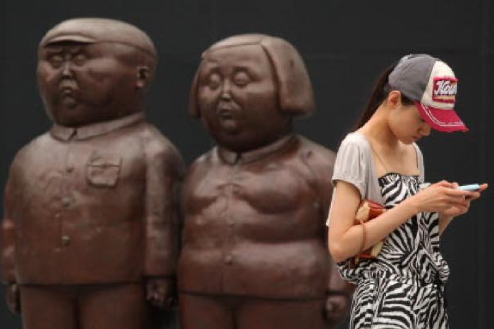 A shopper checks her phone at a Beijing mall. File photo: AFP
