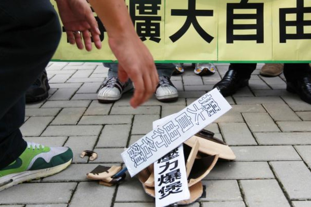 Democratic Party members smash a cooking pot symbolising the pressure on Hong Kong society of the cross-border influx on a march to the central government offices at Admiralty to protest about the multi-entry permits for Shenzhen residents yesterday. Photo: Nora Tam