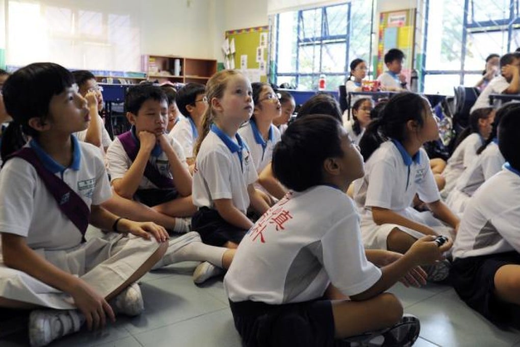 Happy Rogers, centre, the daughter of US investor Jim Rogers, listens to her Chinese teacher in her Mandarin class at Nanyang Primary School in Singapore last May. Photo: AFP