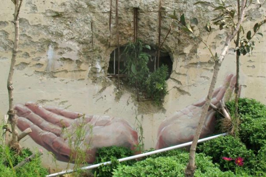 Hands of peace decorate a gaping hole in a waterfront wall on Yeonpyeong Island left by the North Korean artillery barrage of November 23, 2010. Photo: Andrew Salmon