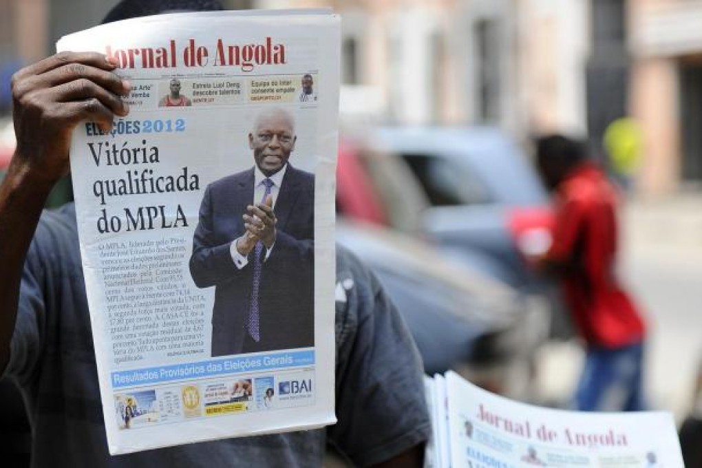 An Angolan newspaper vendor with the day's news. Photo. AFP