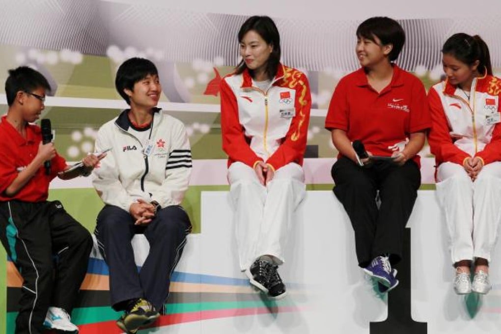 Gold medalists Wu Minxia (centre) and He Zi (right) meet admirers at Queen Elizabeth Stadium during their visit.Photo: Nora Tam