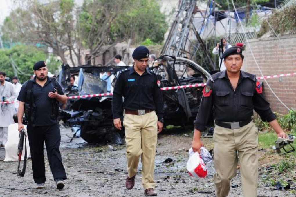 Pakistani policemen collect evidence at the bomb blast site in Peshawar. Photo: AFP
